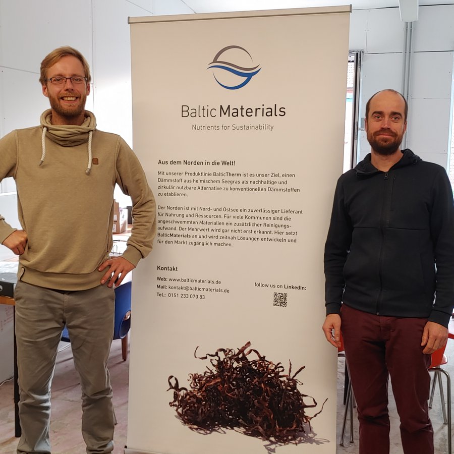 zwei Männer stehen an einem Roll-up
