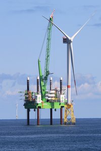 Offshore Windkraftanlage mit Schiff, das Rotorblätter bringt
