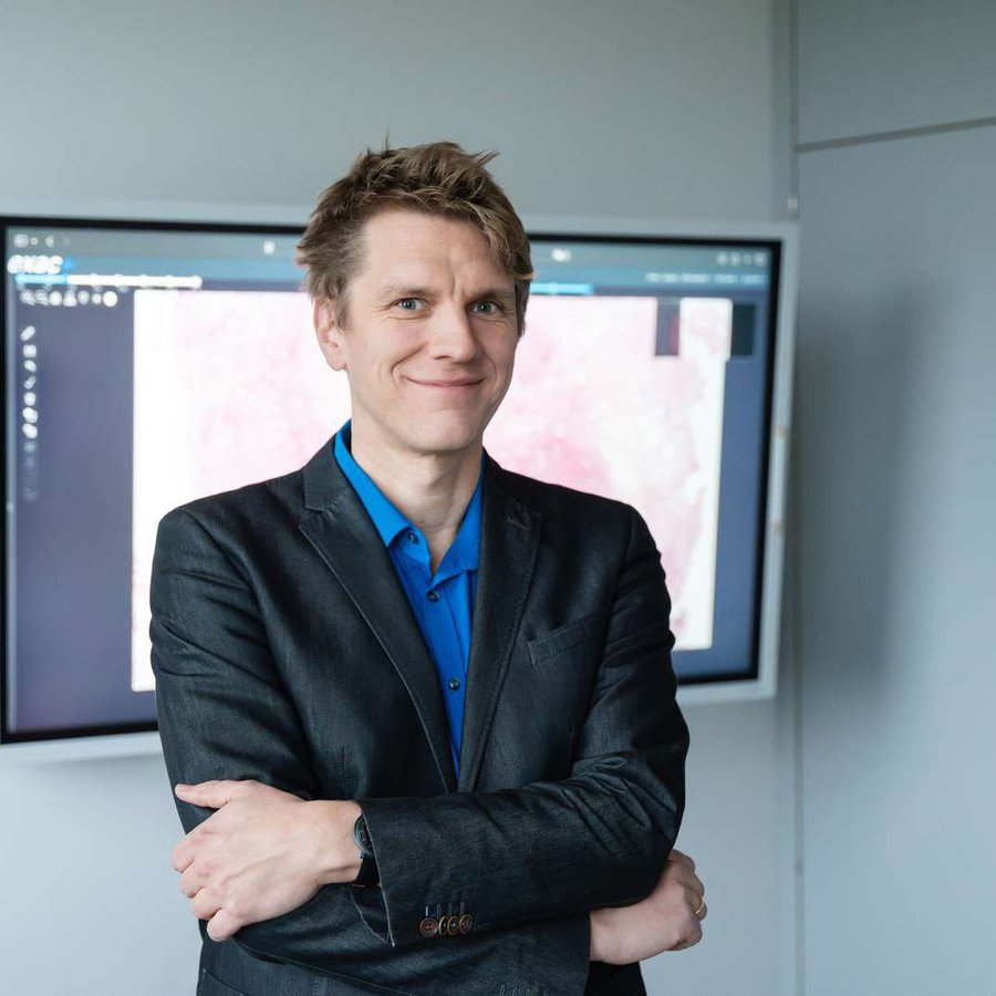 Auf dem Bild ist ein Portrait von Marc Aubreville zu sehen. Er hat die Arme verschräntk und lächelt in die Kamera.