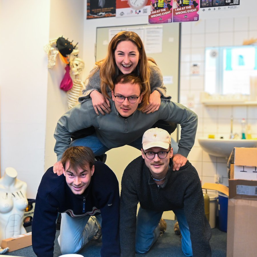 vier Personen bilden eine Pyramide.