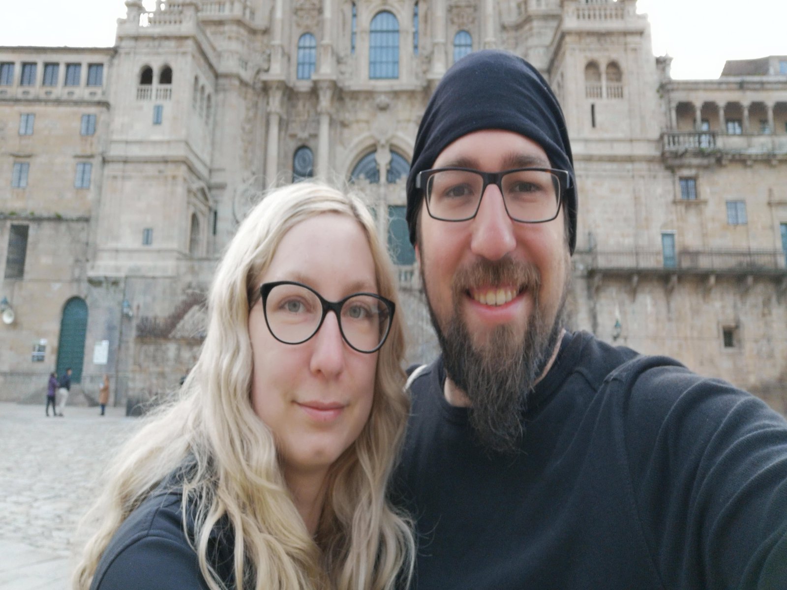 Eine Frau und ein Mann posieren vor einer Kathedrale aus Sandstein.