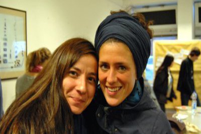 Zwei Frauen, lächeln dicht an dicht in die Kamera.