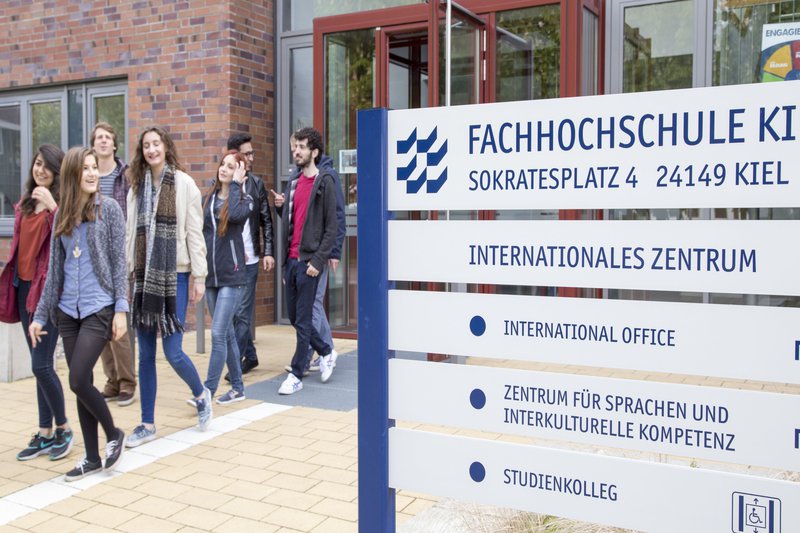 Campusimpression International Office Studierende vom Gebäude des ZSIK neben einer Infotafel