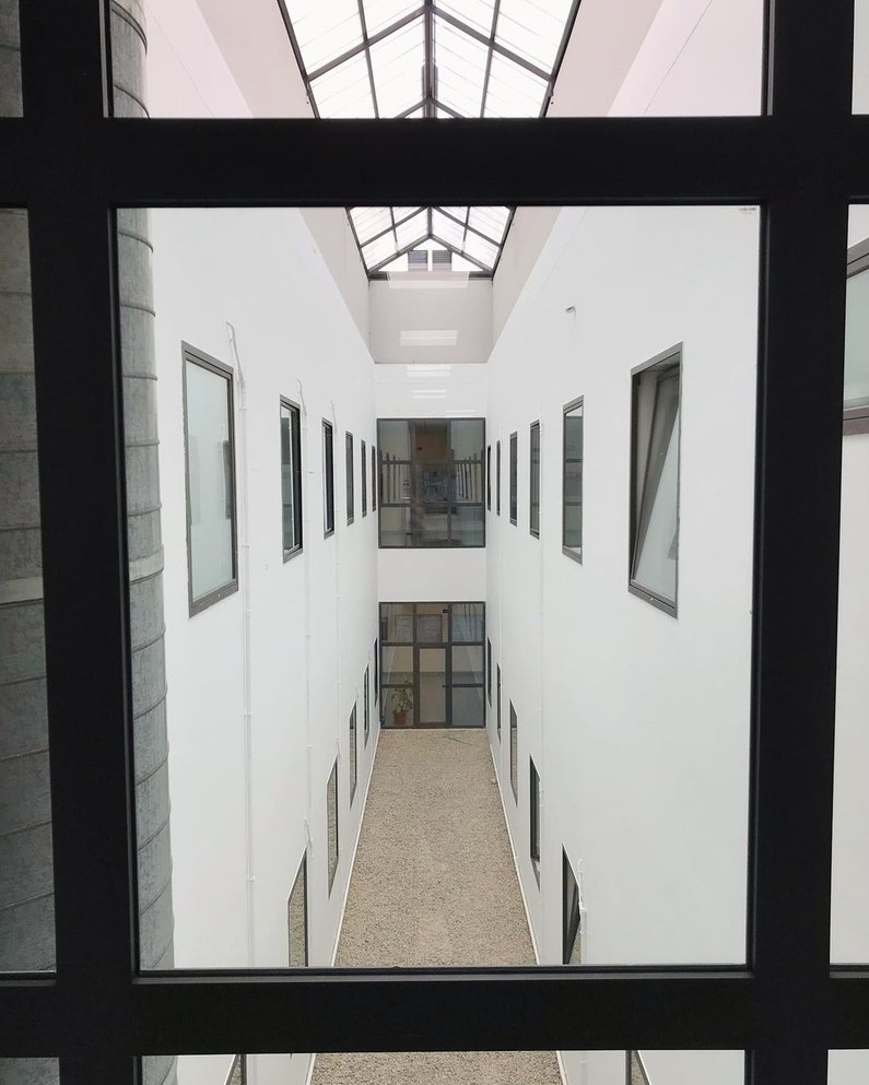 Moderner minimalistischer Flur mit hohen Decken und Lichteinfall durch Deckenfenster in der Santander Universität