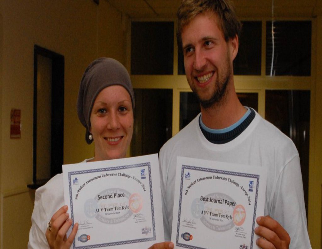 Ein Mann und eine Frau halten Stolz ihre Auszeichnungen in die Kamera.