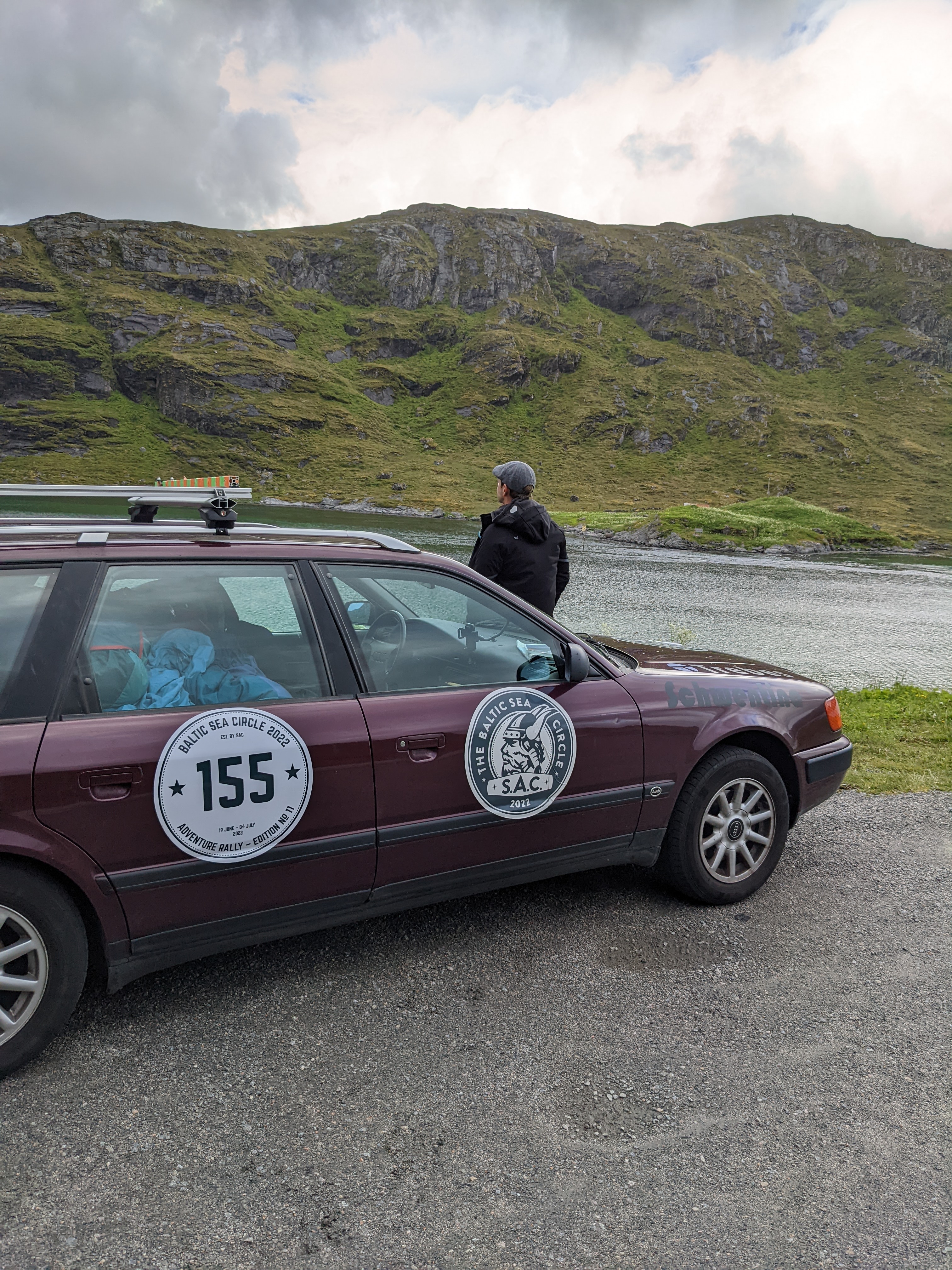 ein Auto, dahinter steht ein Mann