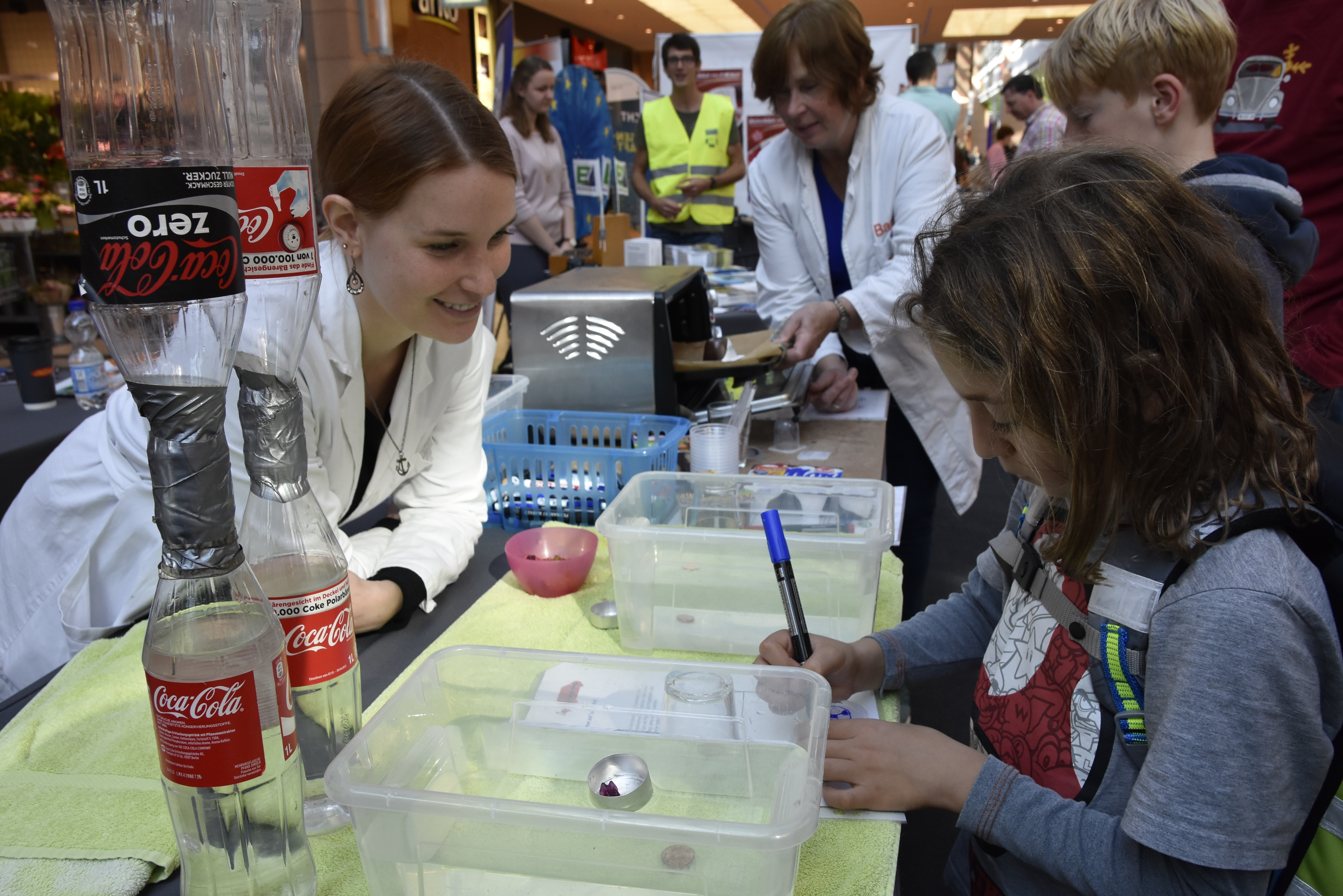 ein Kind und eine Frau an einem Versuchstisch