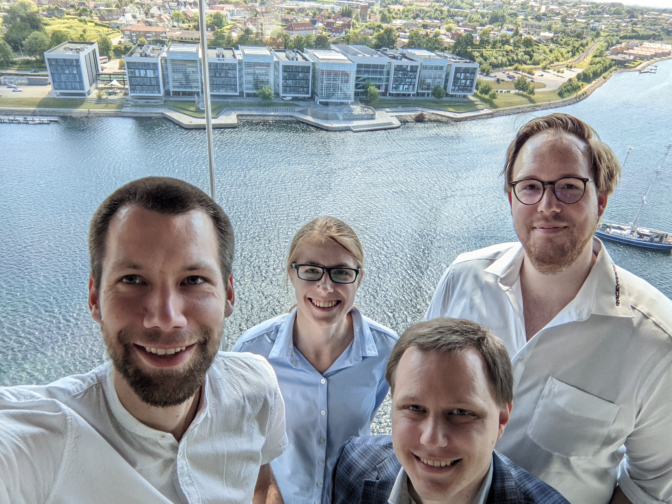 vier Personen vor der Kulisse der SDU in Sonderborg