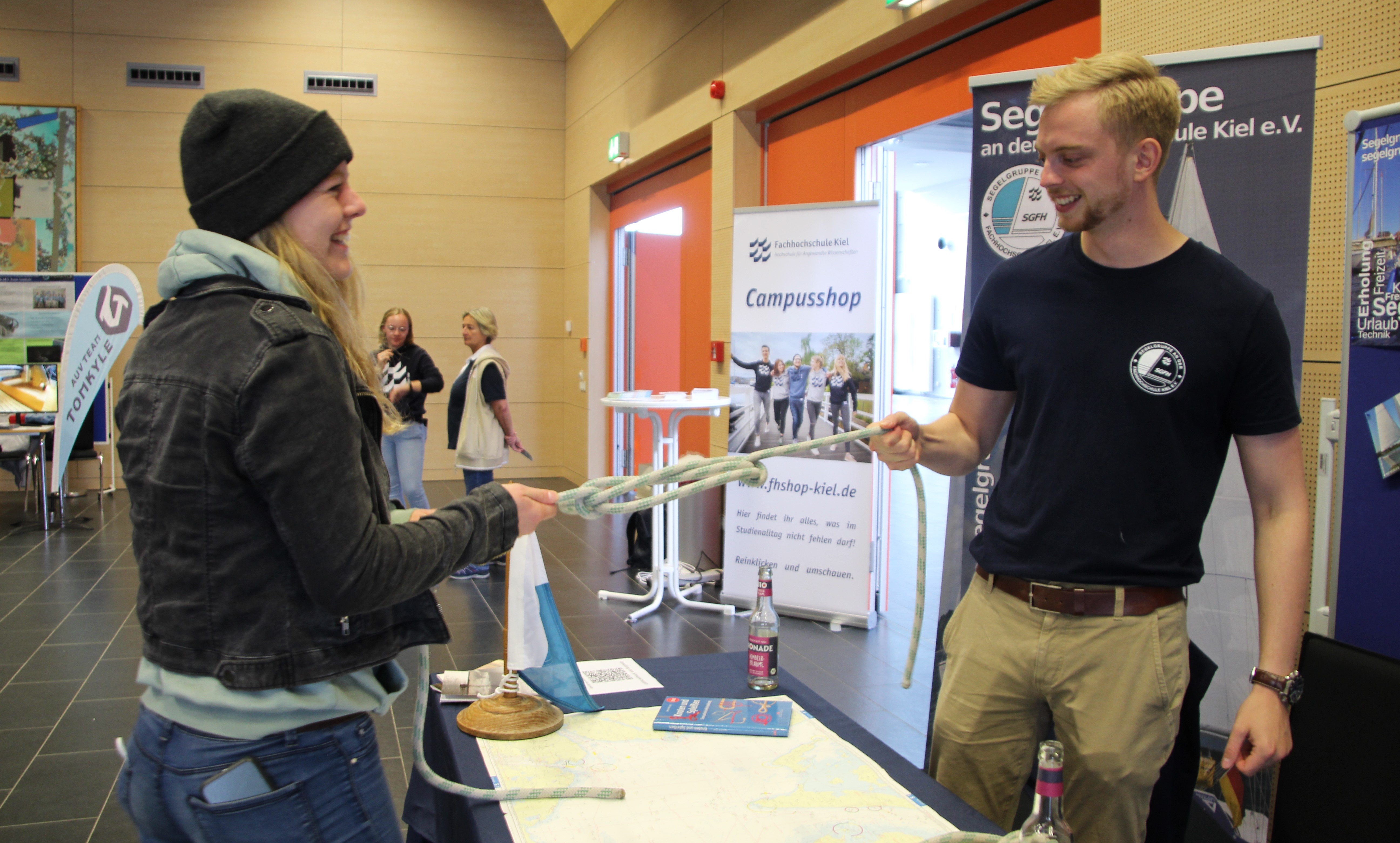 Eine Frau und ein Mann stehen sich gegenüber und ziehen an einem Tampen