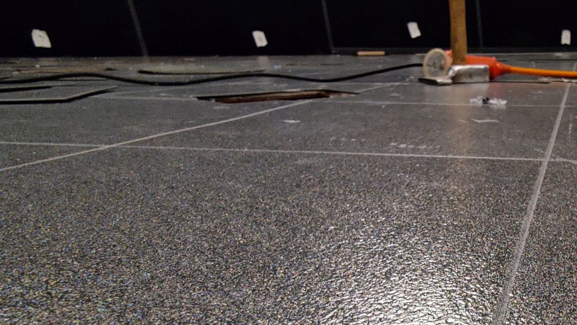 Neue anthrazitgraue PVC-Fliesen im Mediendom, Arbeitsgeräte im Hintergrund