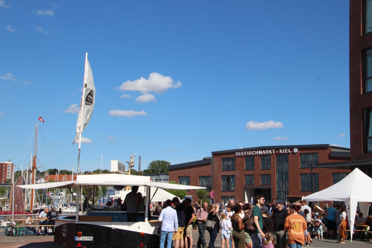 Menschen auf einem Platz auf dem Gelände des Seefischmarktes Kiel