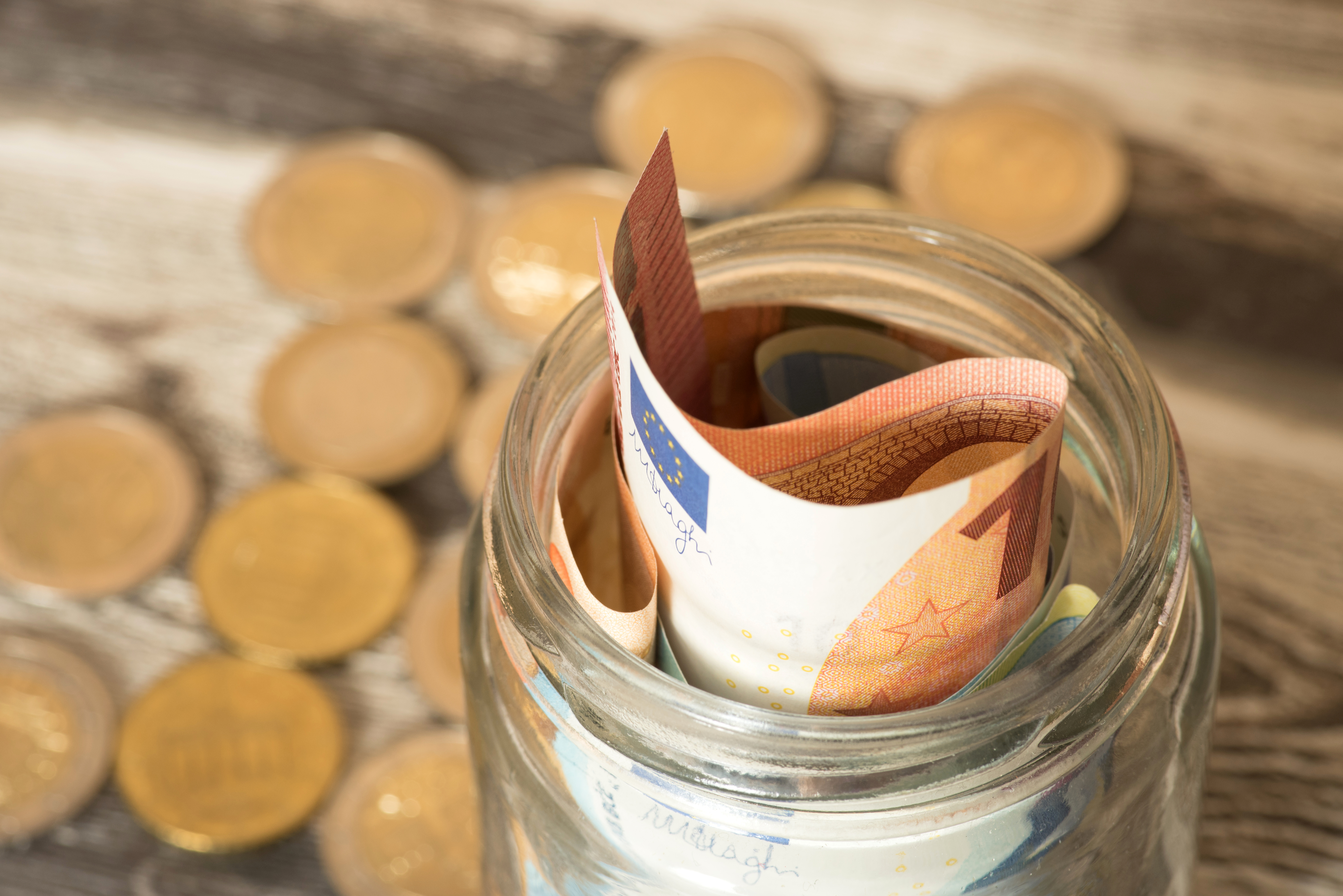 Euro Geldscheine und Münzen und ein Einmachglas ein Glas mit Geldstücken und -scheinen
