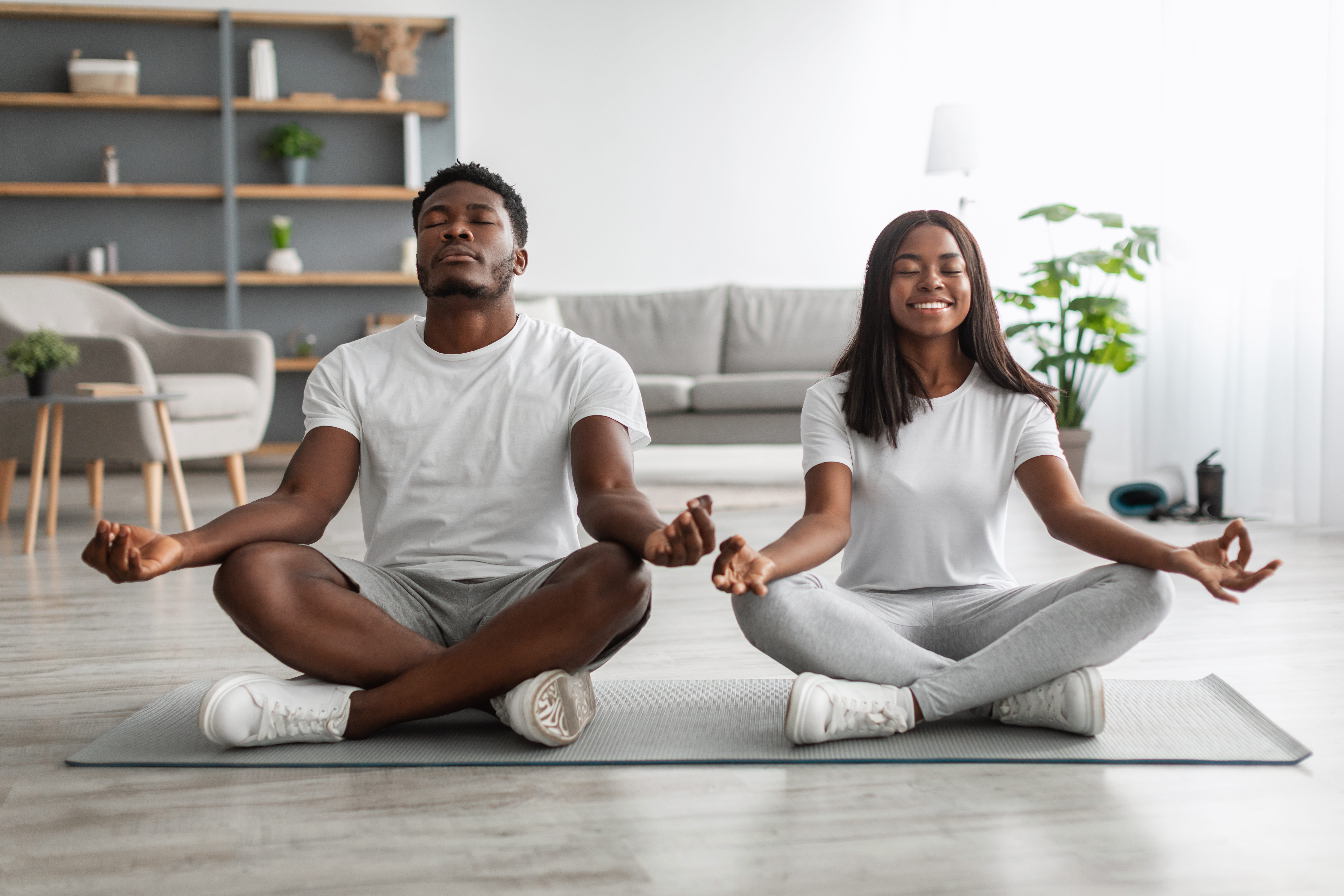Black couple meditating keeping hands and fingers in mudra gestu ein Mann und eine Frau beim Yoga