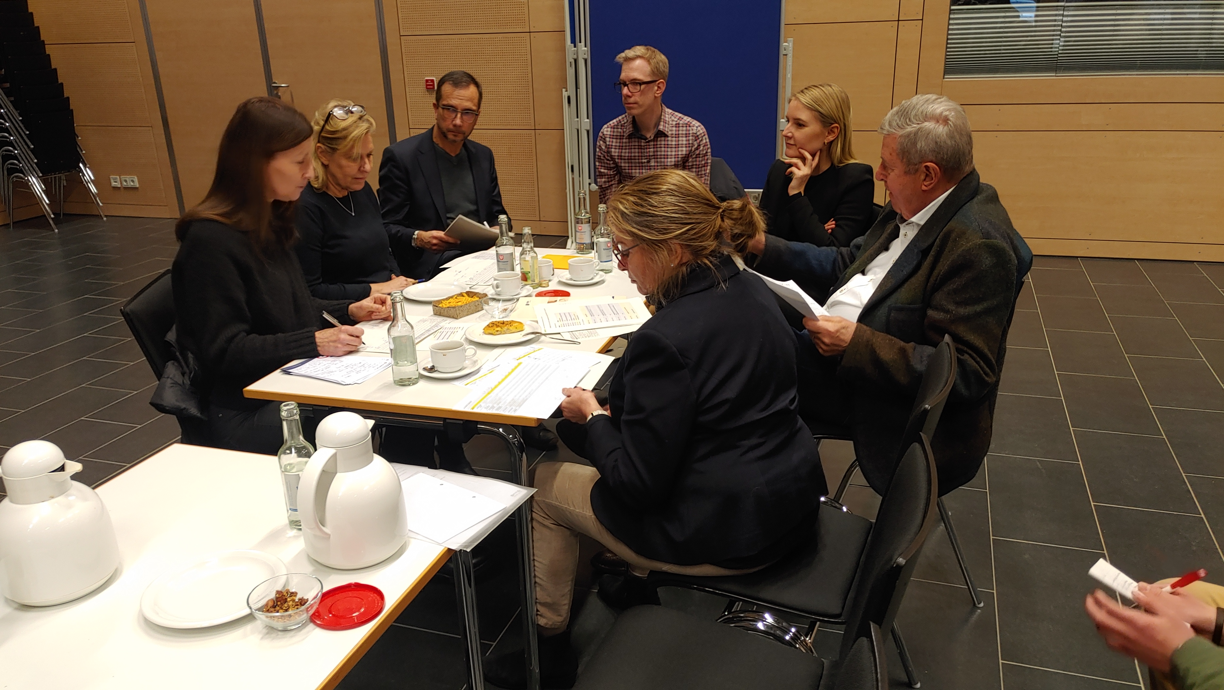 mehrere Personen sitzen um einen Tisch herum
