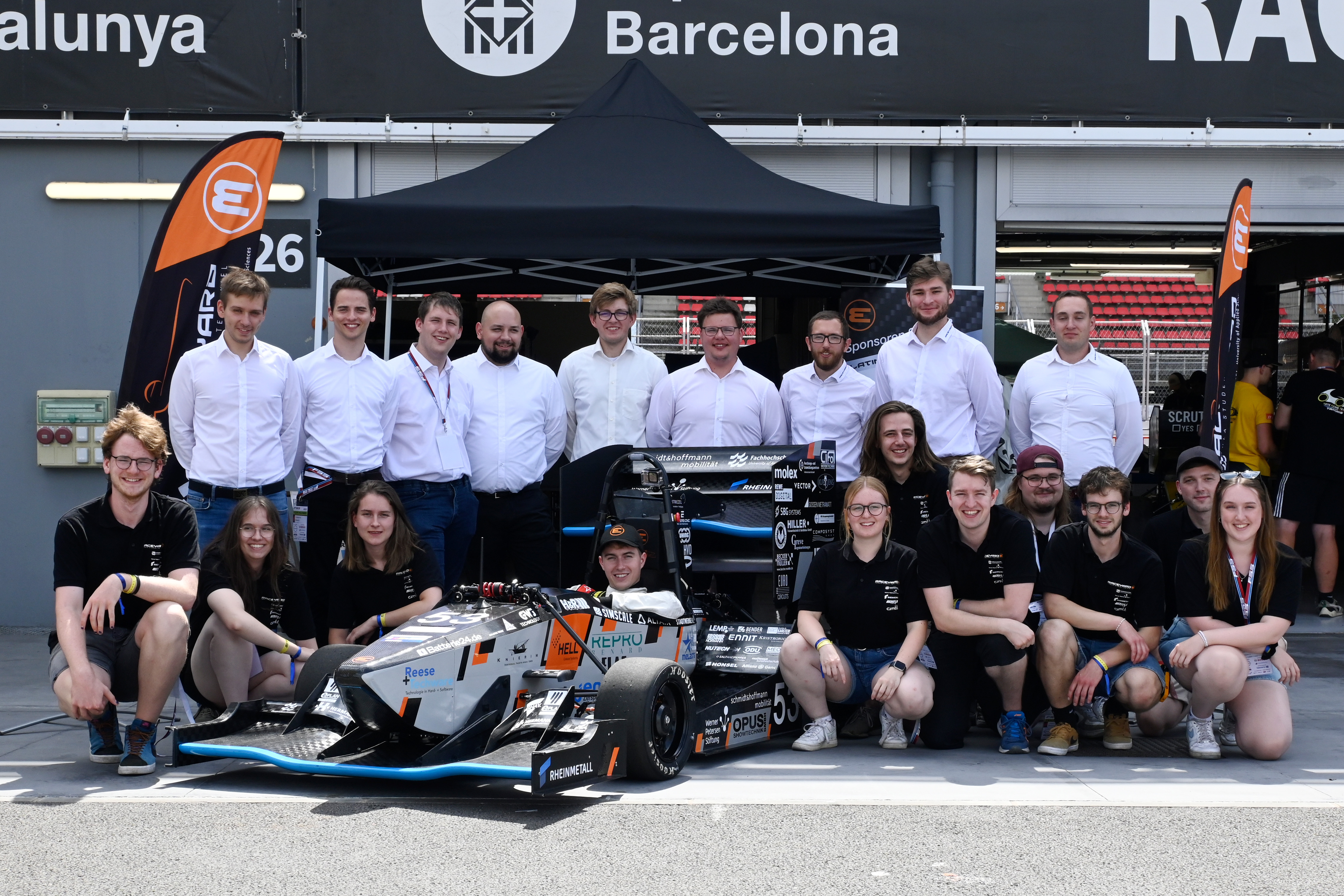 Gruppenfoto von Studierenden mit ihrem Rennauto auf dem Circuit in Spanien