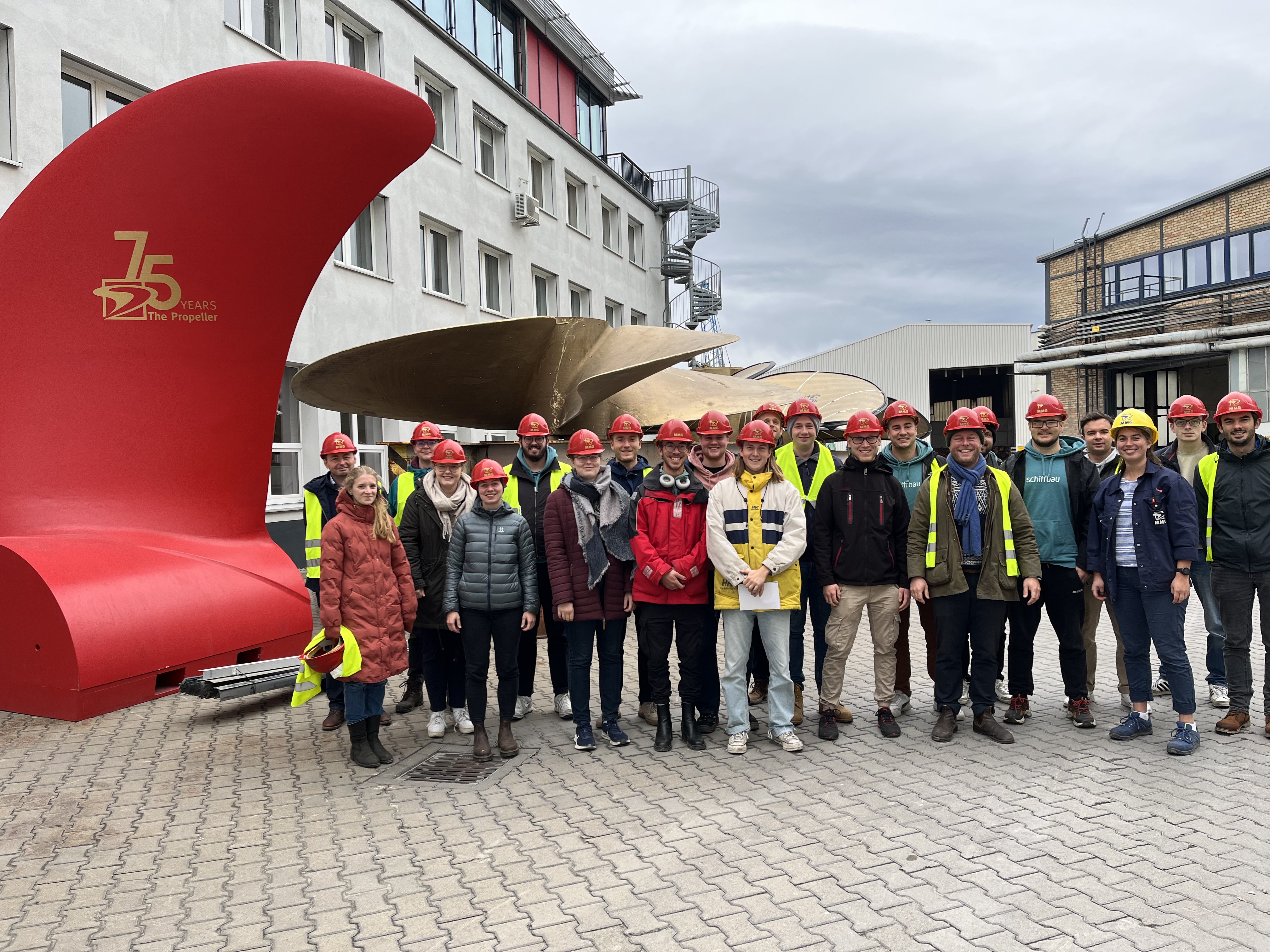 Eine Gruppe Menschen vor einem Propeller.