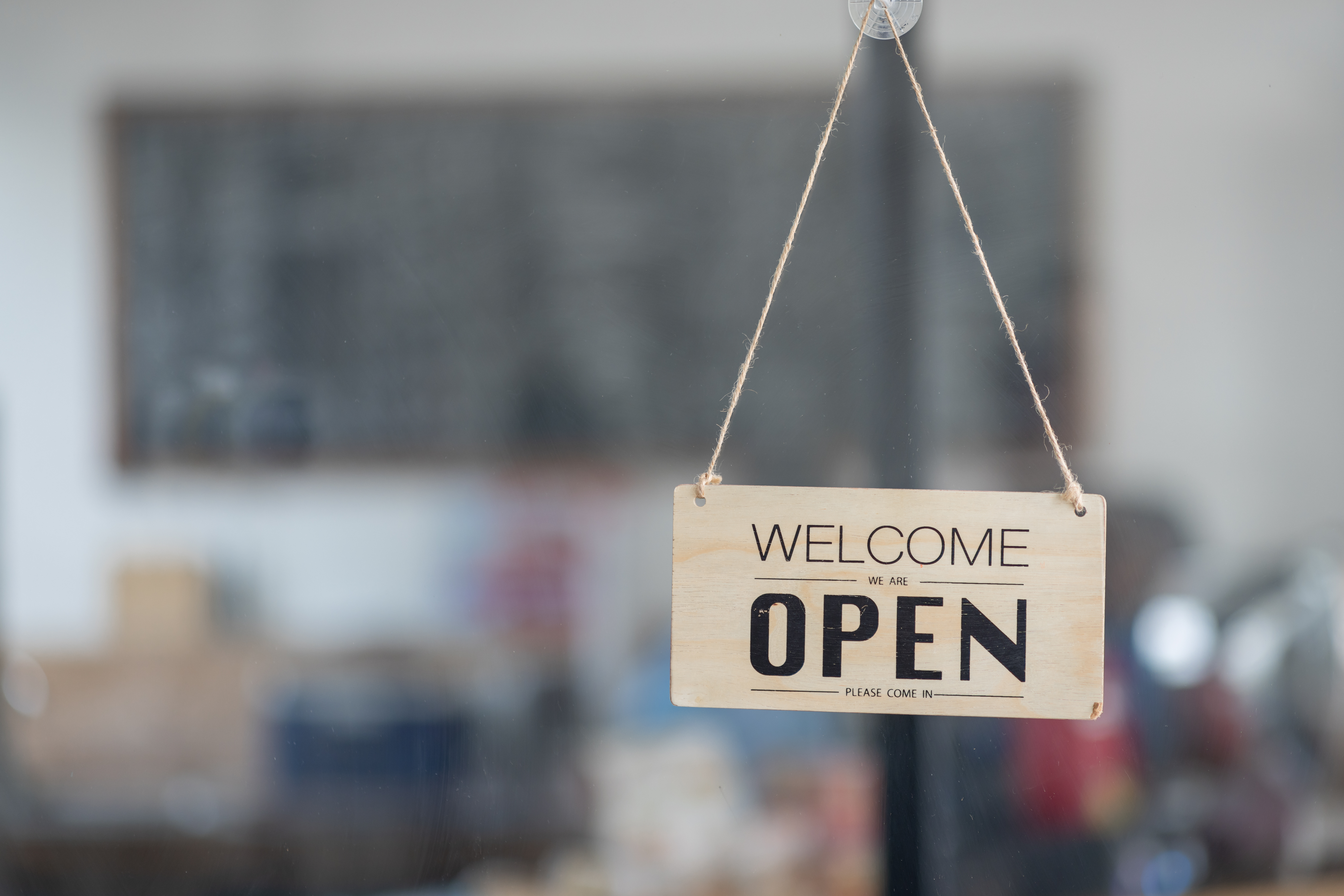 Hinweisschild "We are open" an einer Glastür