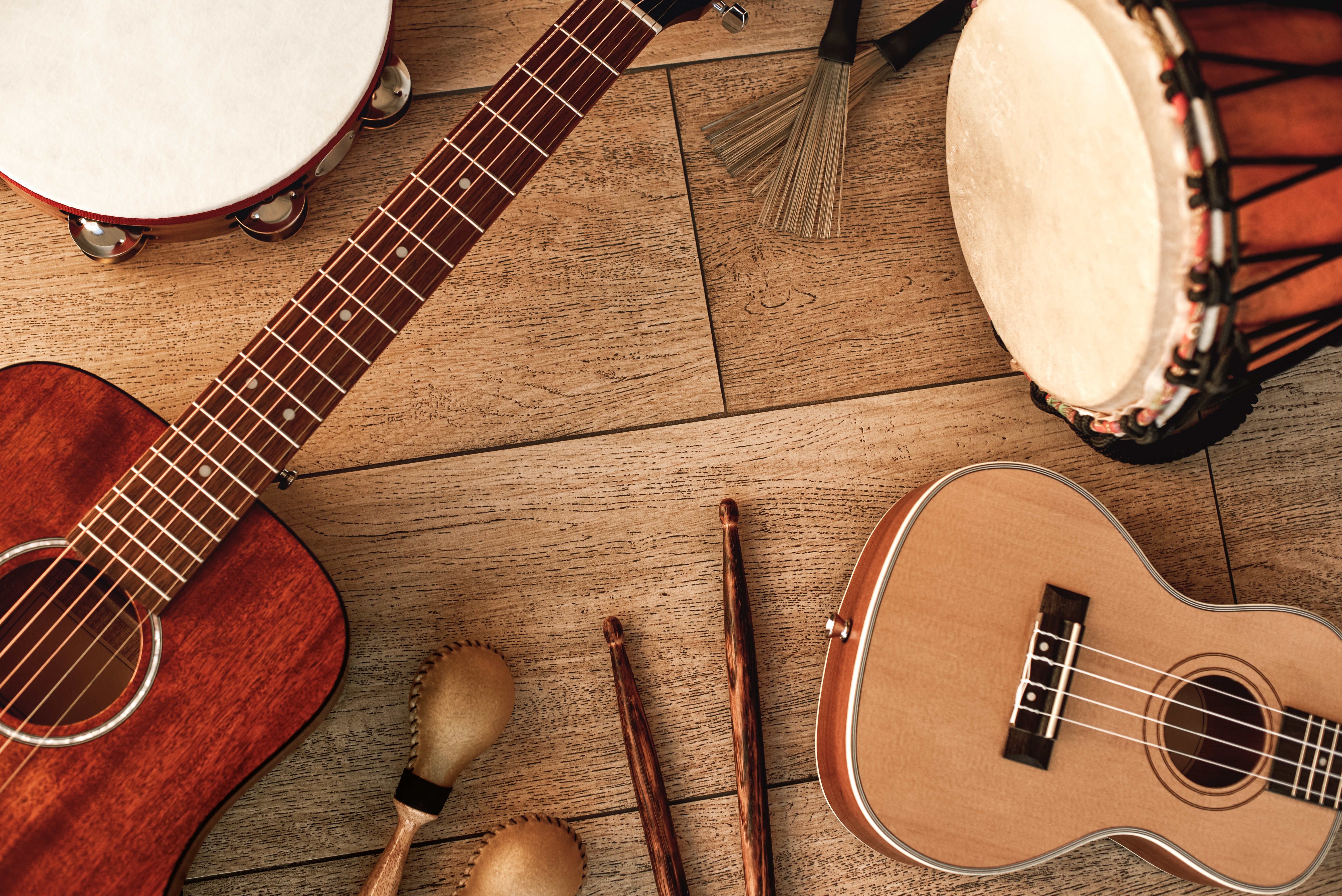 Ethnic musical instruments set: tambourine, wooden drum, brushes Blick von oben auf eine Schelle, eine Trommel, eine Okulele und eine Gitarre