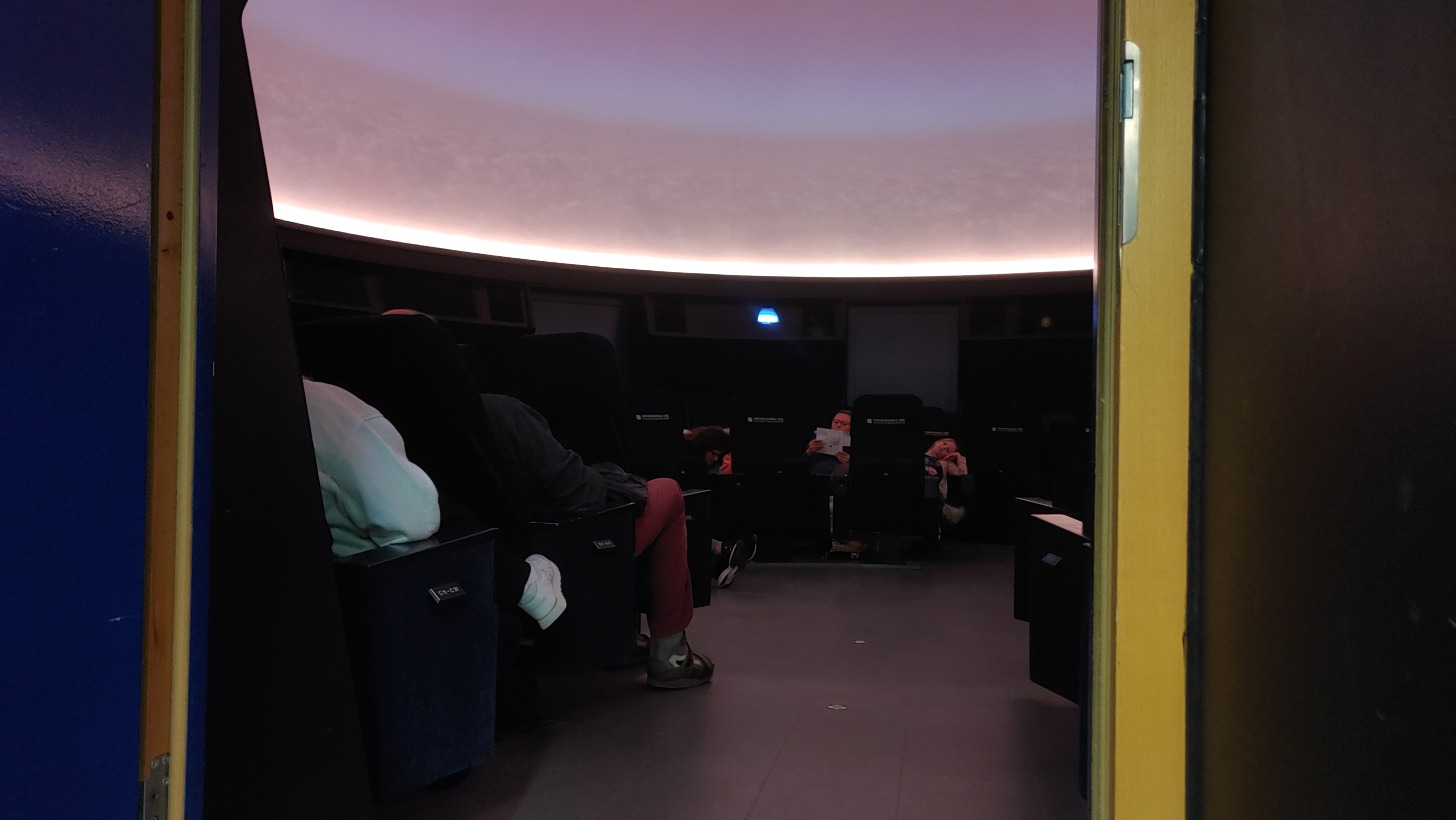 Blick in den Mediendom an der FH Kiel, wo Besucherinnen und Besucher des Science Day 2023 in Kiel auf den Beginn der ersten Vorstellung warten