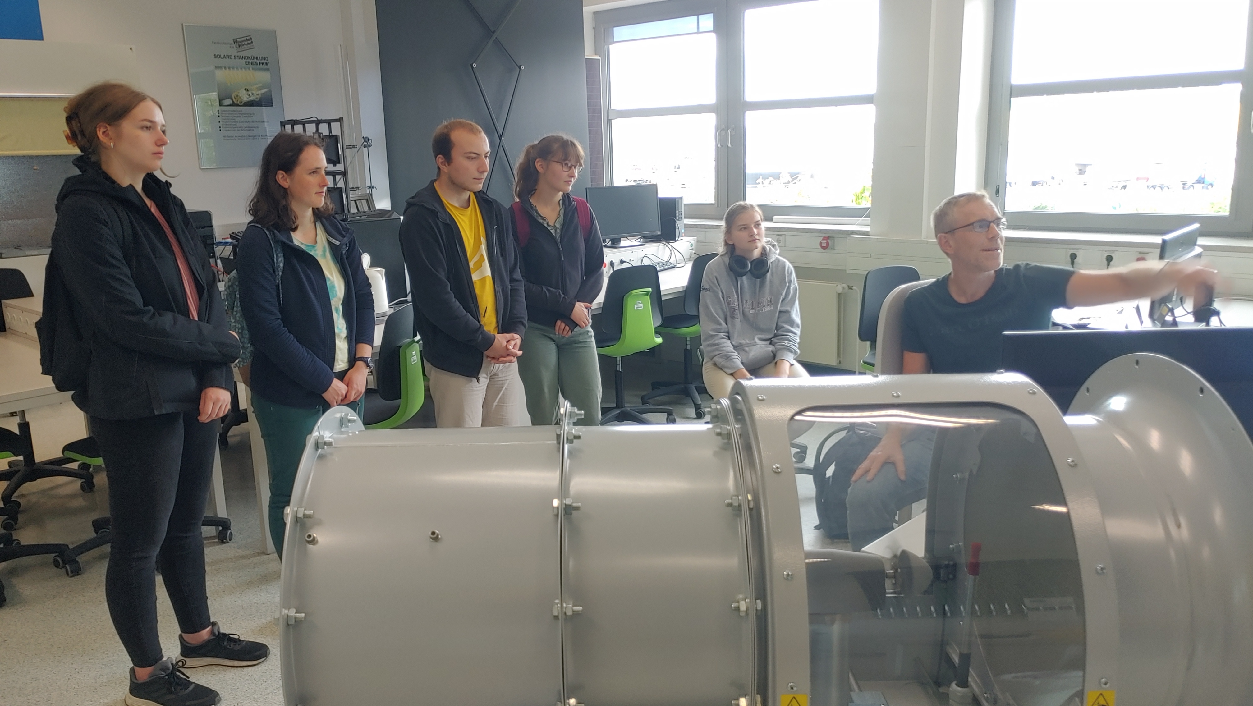 Prof. Andreas Luczak erklärt Besucherinnen und Besuchern des Science Day am Modell, wie Windkraftanlagen funktionieren