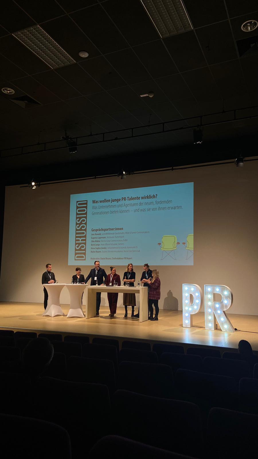 6 Personen stehen auf einer Bühne