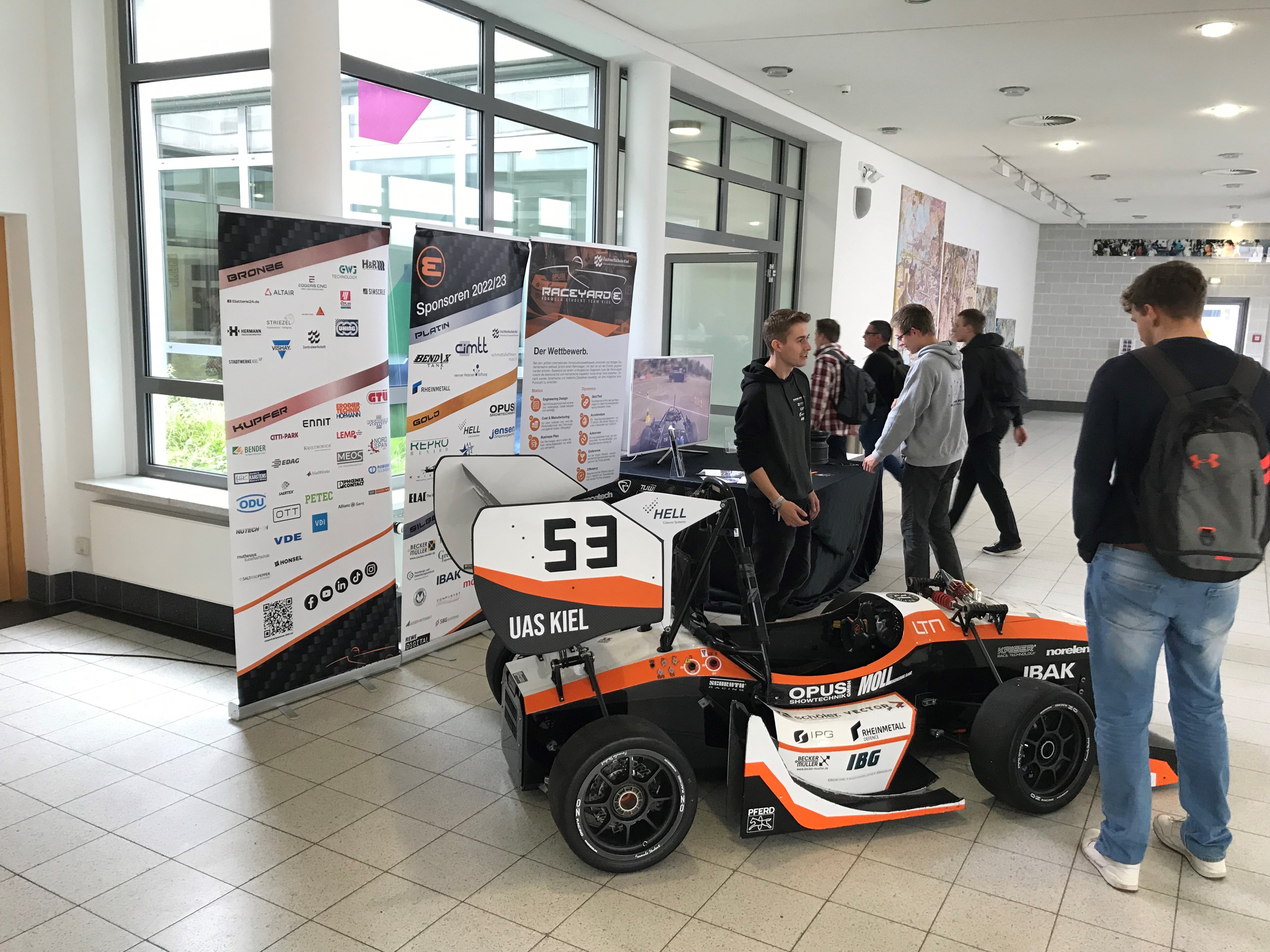 ein Rennwagen des Formula Student Teams Raceyard beim Science Day an der FH Kiel, drumherum stehen Studierende