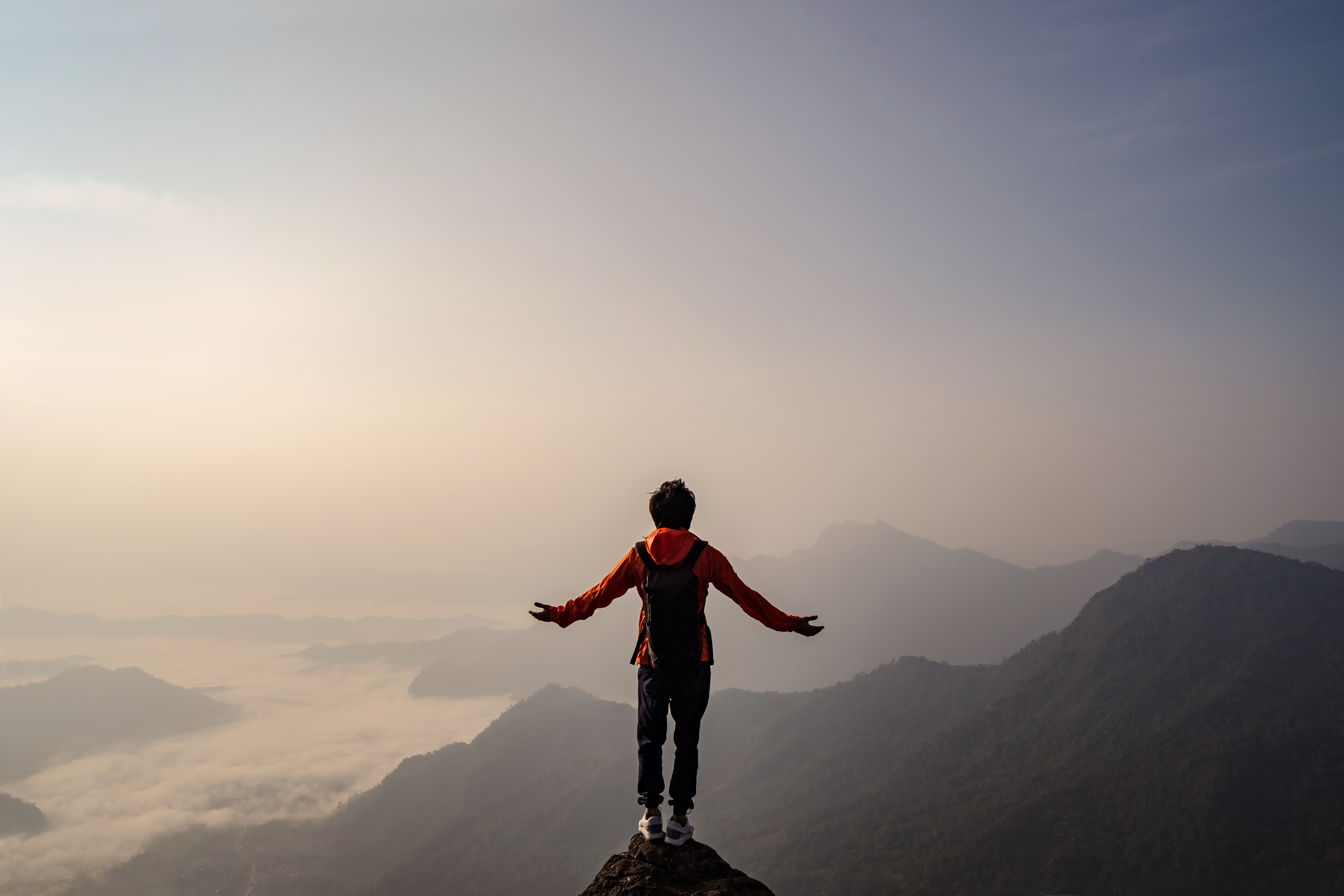 Young traveler standing and looking at beautiful landscape Mensch auf einem Berg