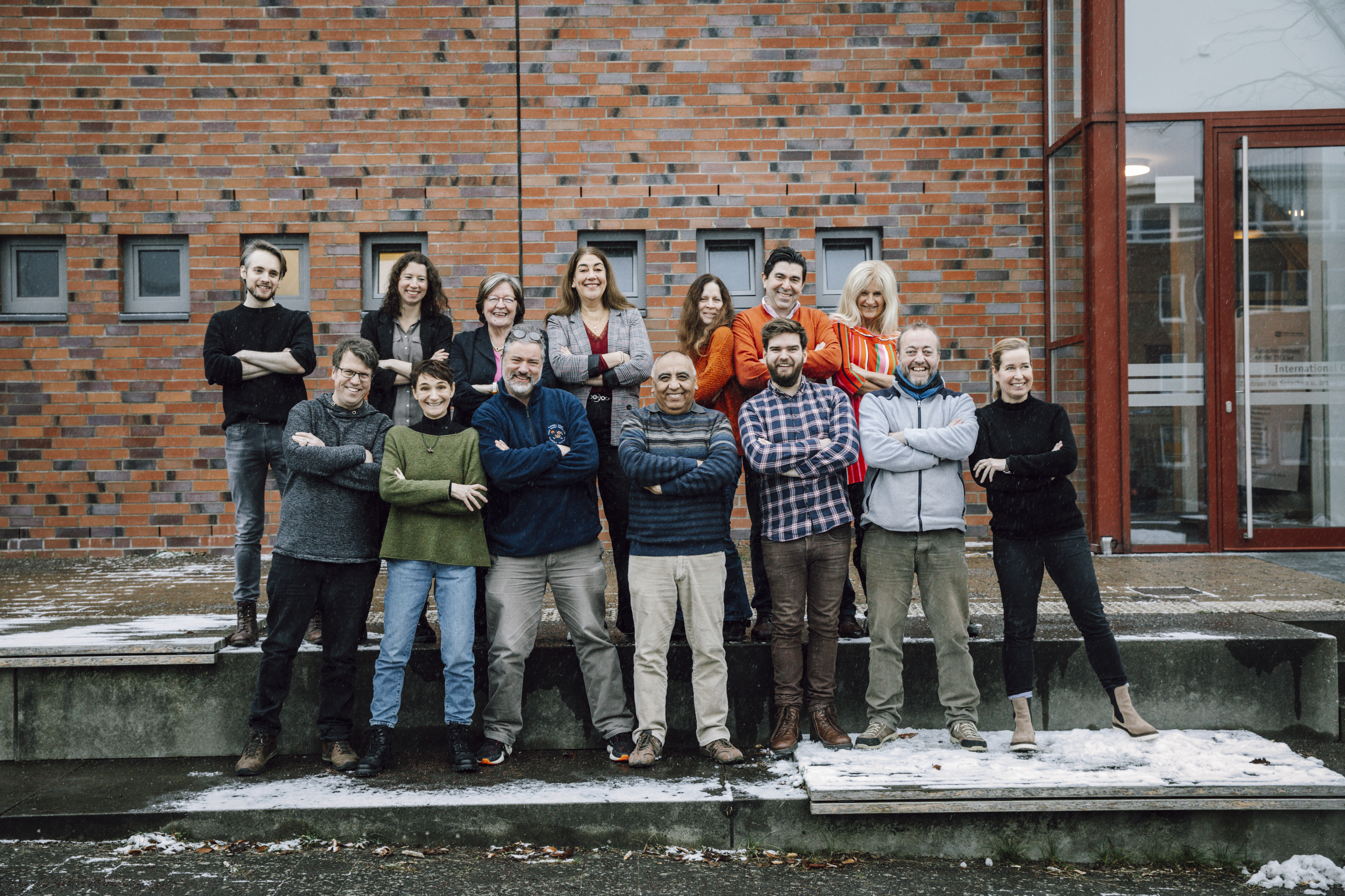 eine Gruppe von Mitarbeitenden des Zentrums für Sprachen und Interkulturelle Kompetenz steht vor ihrem Gebäude am Sokratesplatz