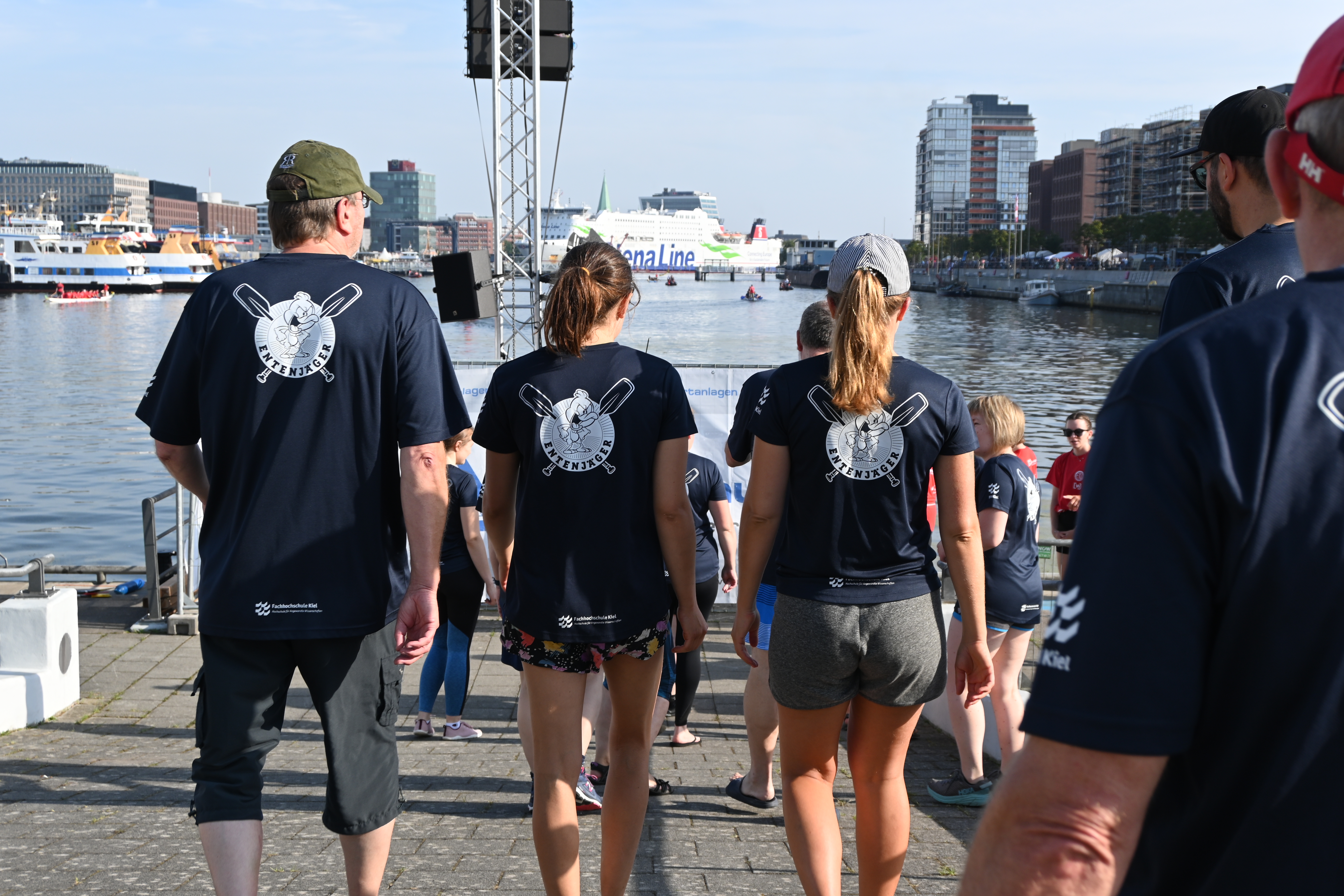 Drei Personen des Teams mit Shirt