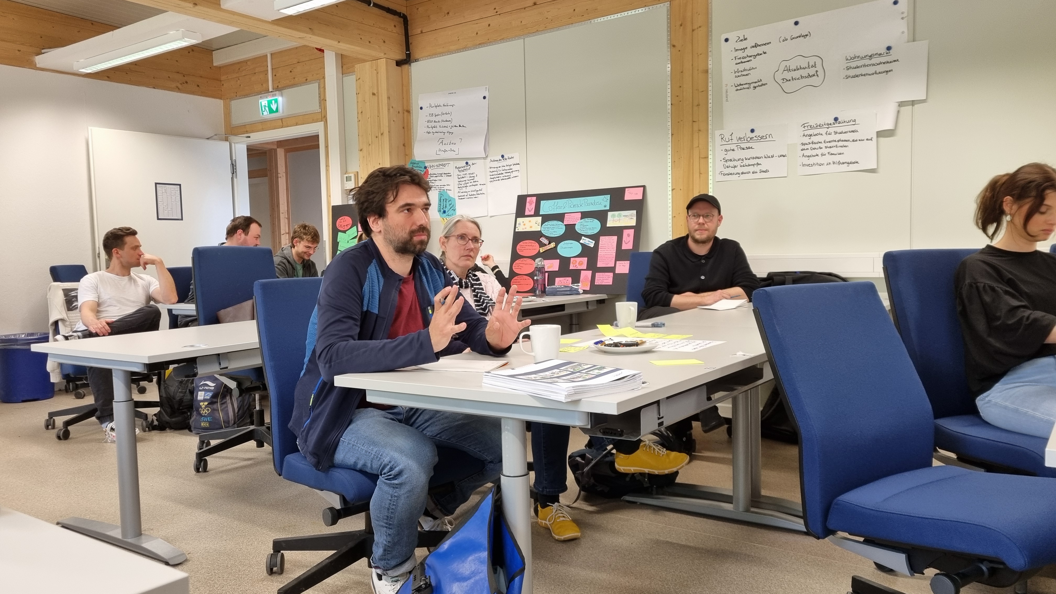 Mehrere Personen hören einem Vortragenden zu