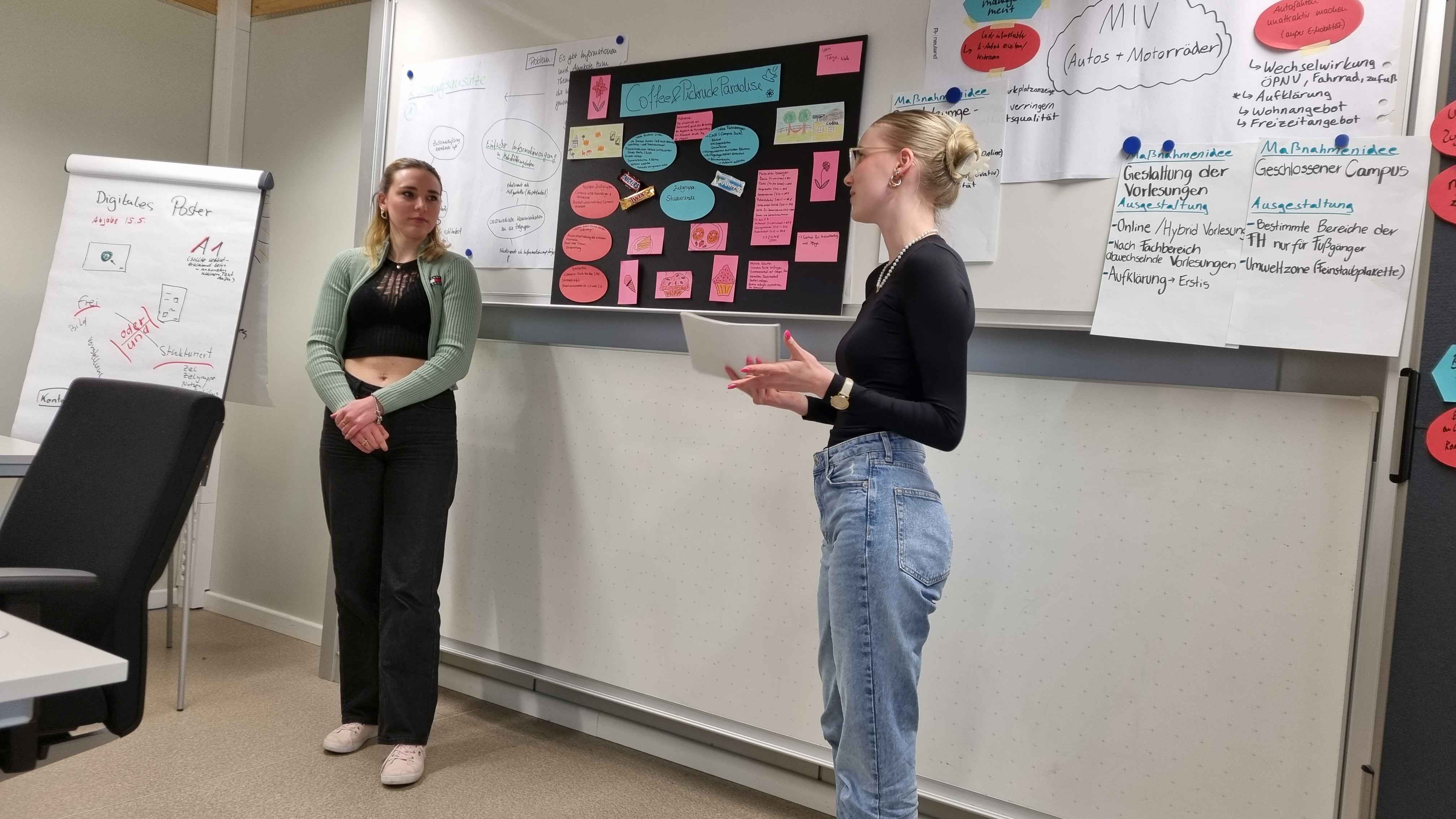 Zwei Frauen stellen ein Plakat vor