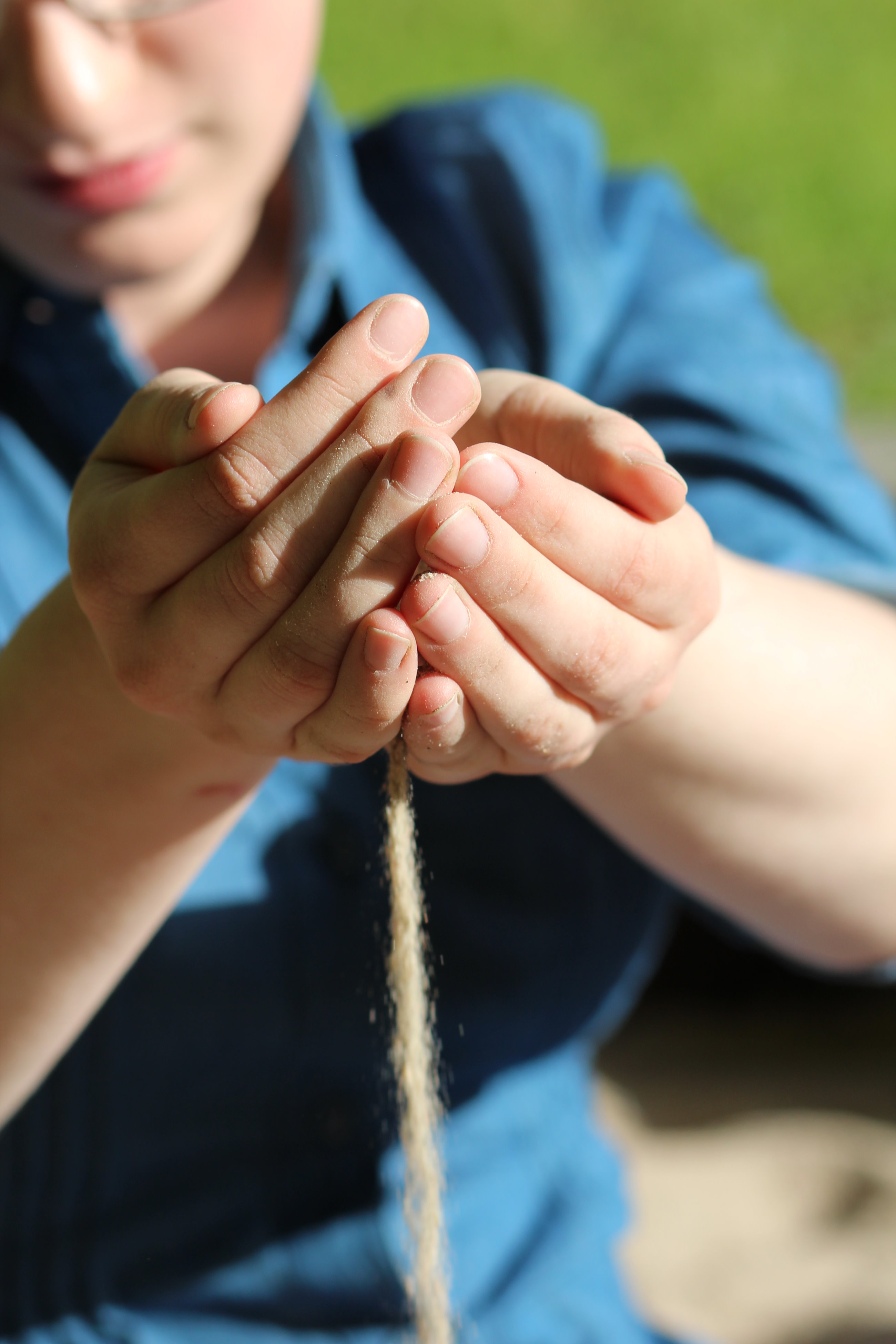 Sand, der durch Hände gleitet