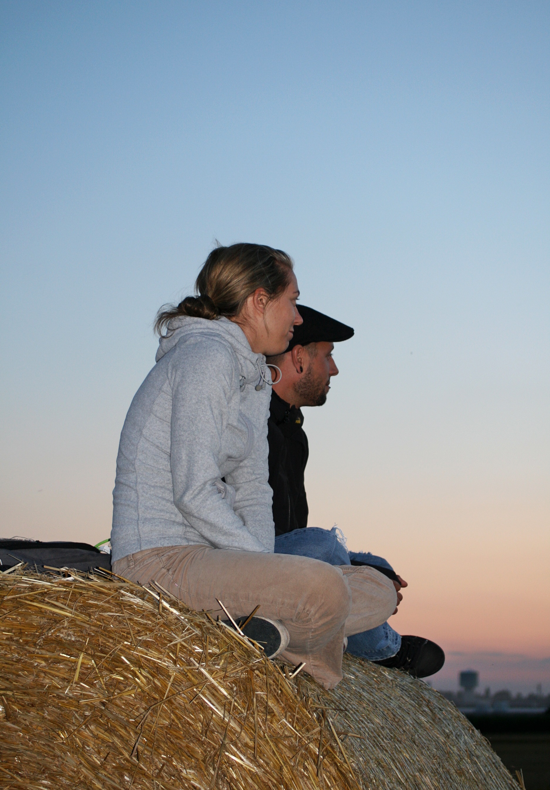 Zwei Menschen schauen beim Sonneruntergang zu