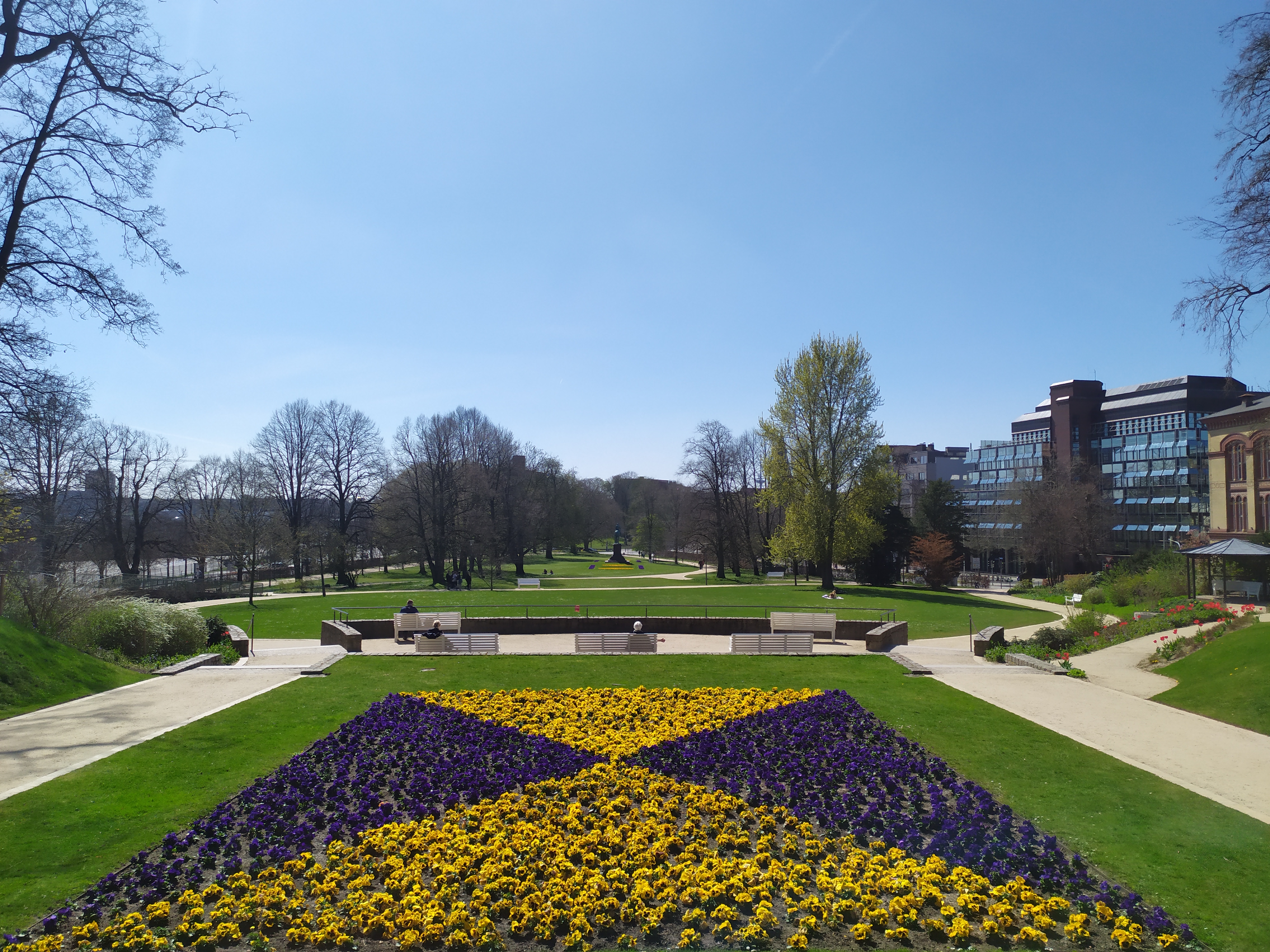 Blick auf einen Park, im Vordergrund einen Blumenbeet.