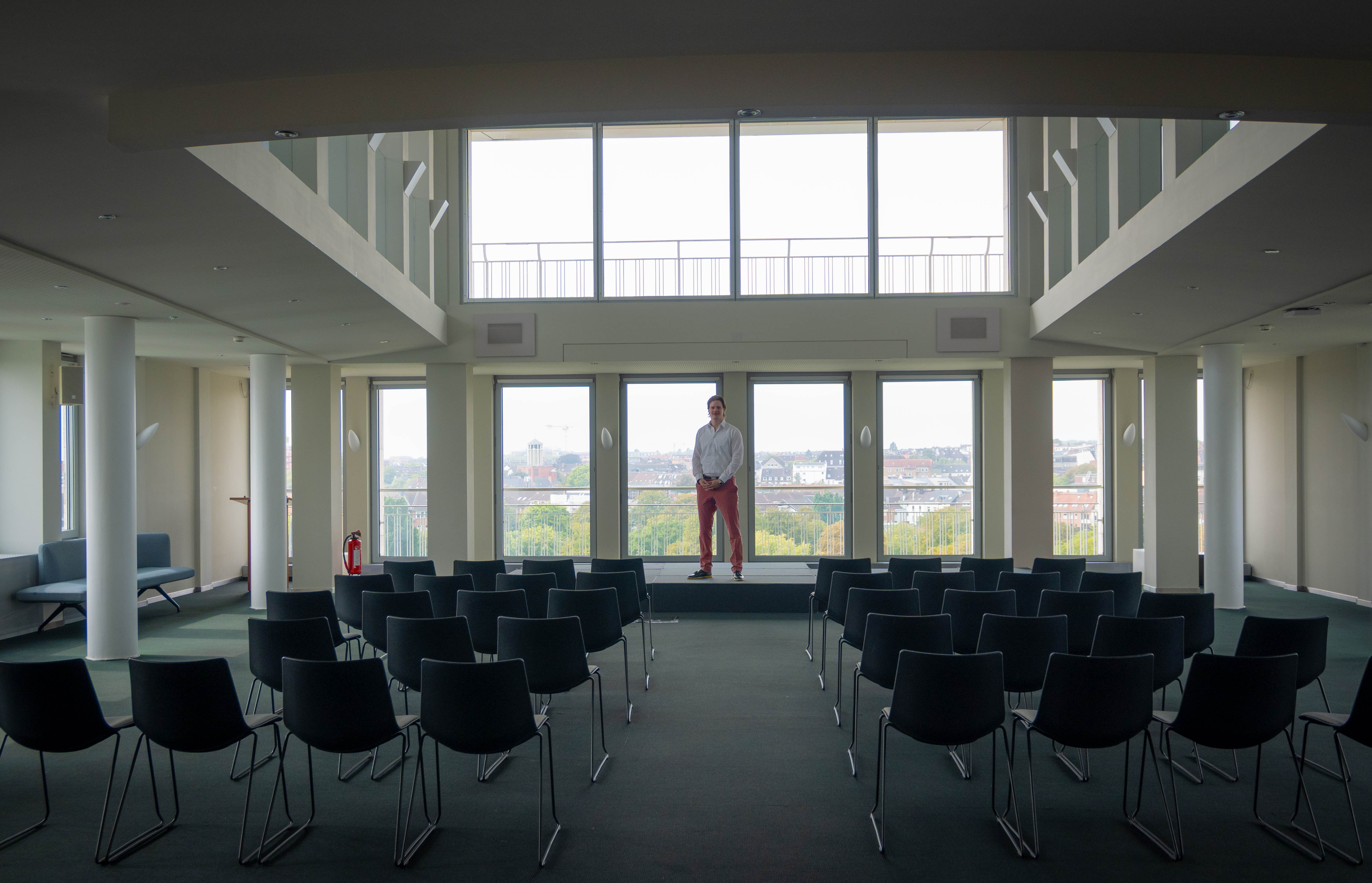 Hansen steht vor einer großen Fensterfront.