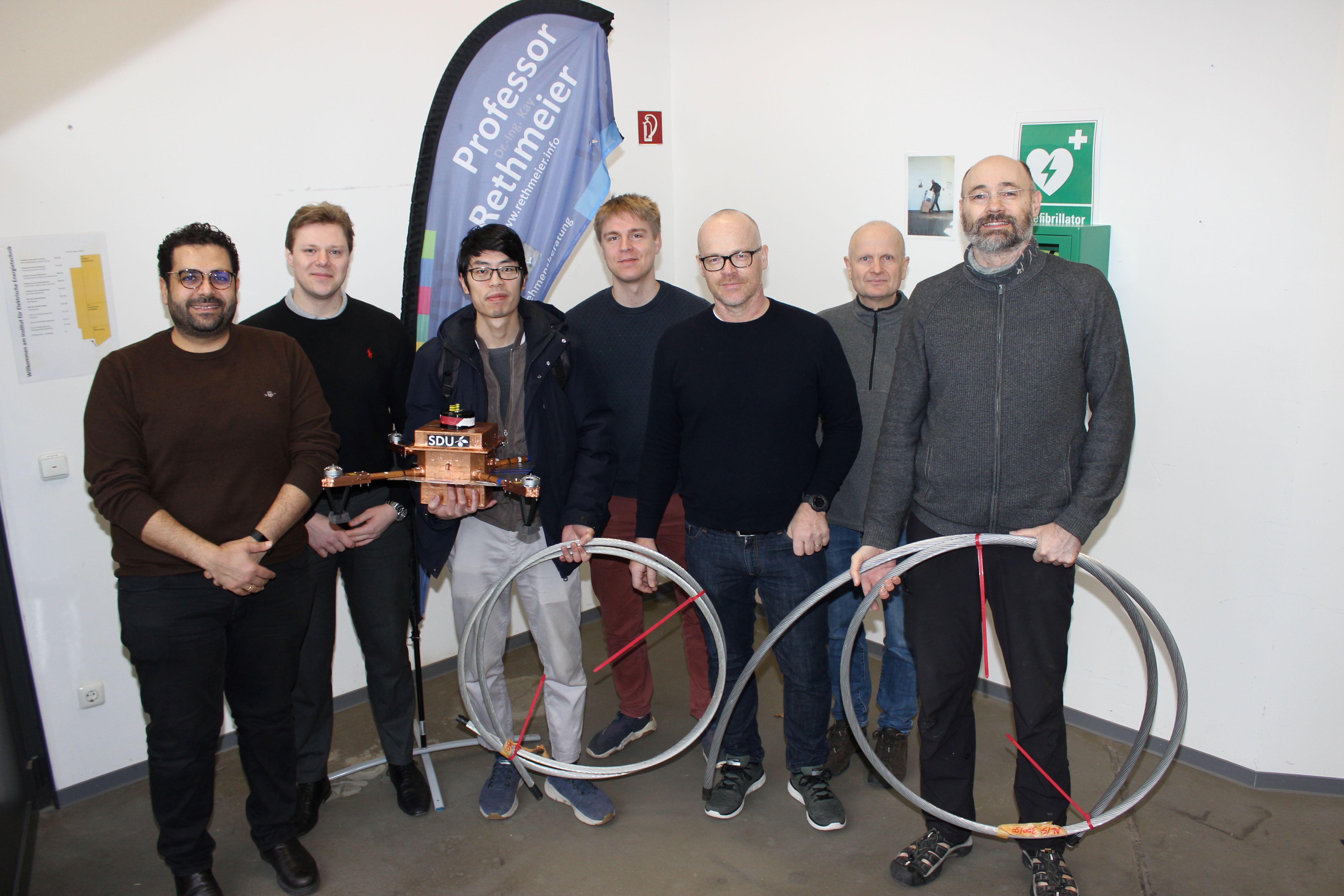 sieben Wissenschaftler aus Deutschland und Dänemark stehen nebeneinander im Blitzlabor der FH Kiel