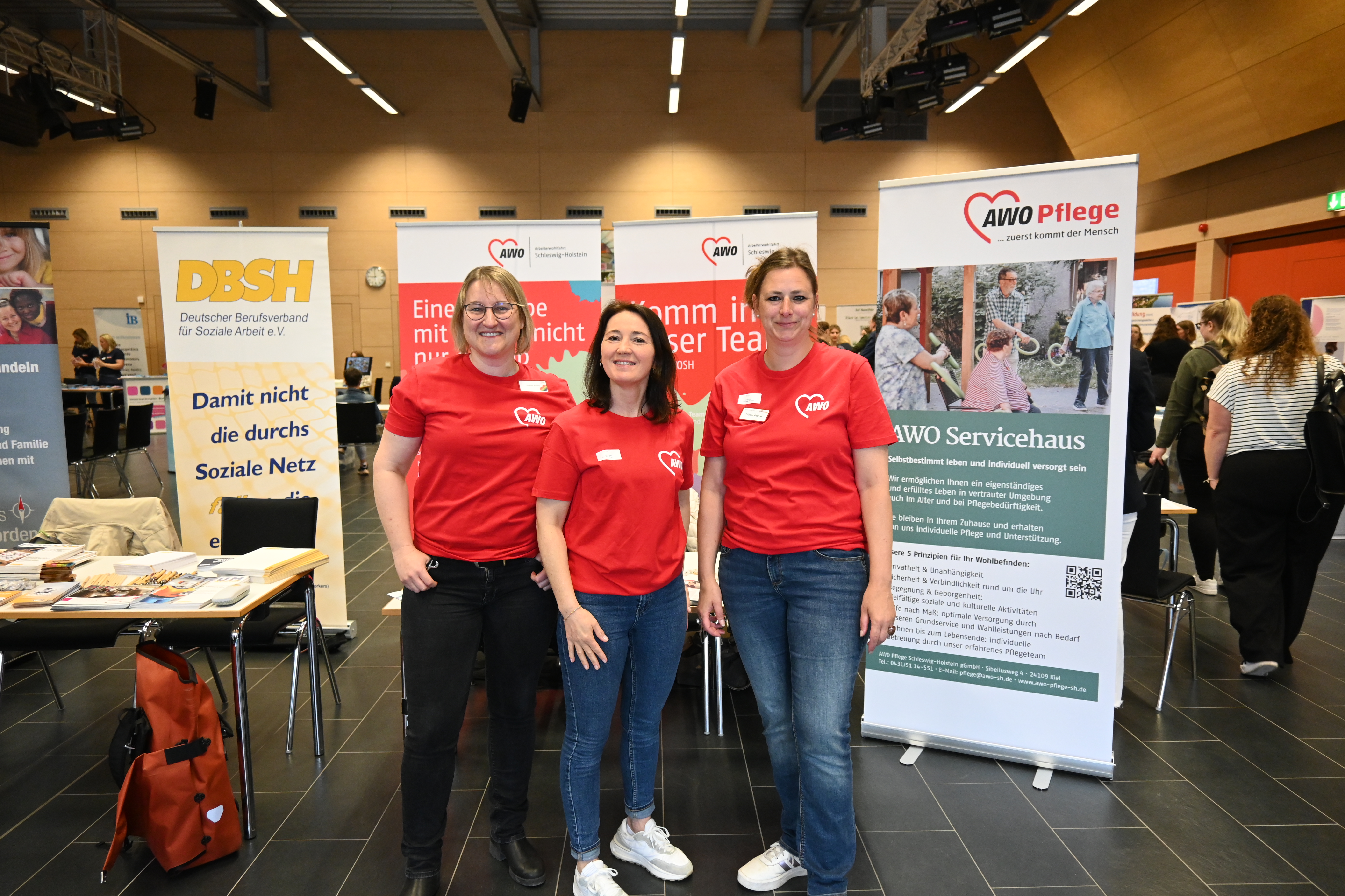 Praxisvertreter*innen der AWO stehen vor ihren Rollups bei der Praxismesse der Sozialen Arbeit an der FH Kiel