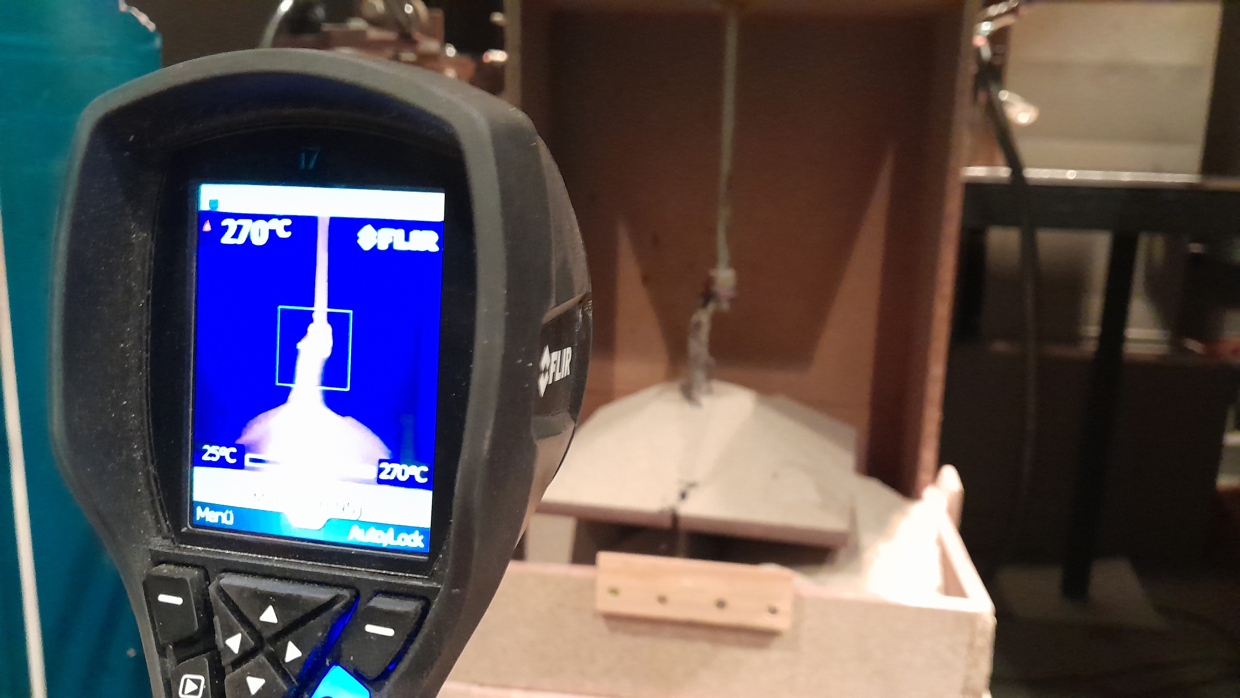 im Vordergrund eine Temperaturkamera, die den Versuchsaufbau mit der Fulgurit-Maschine im Hintergrund überwacht