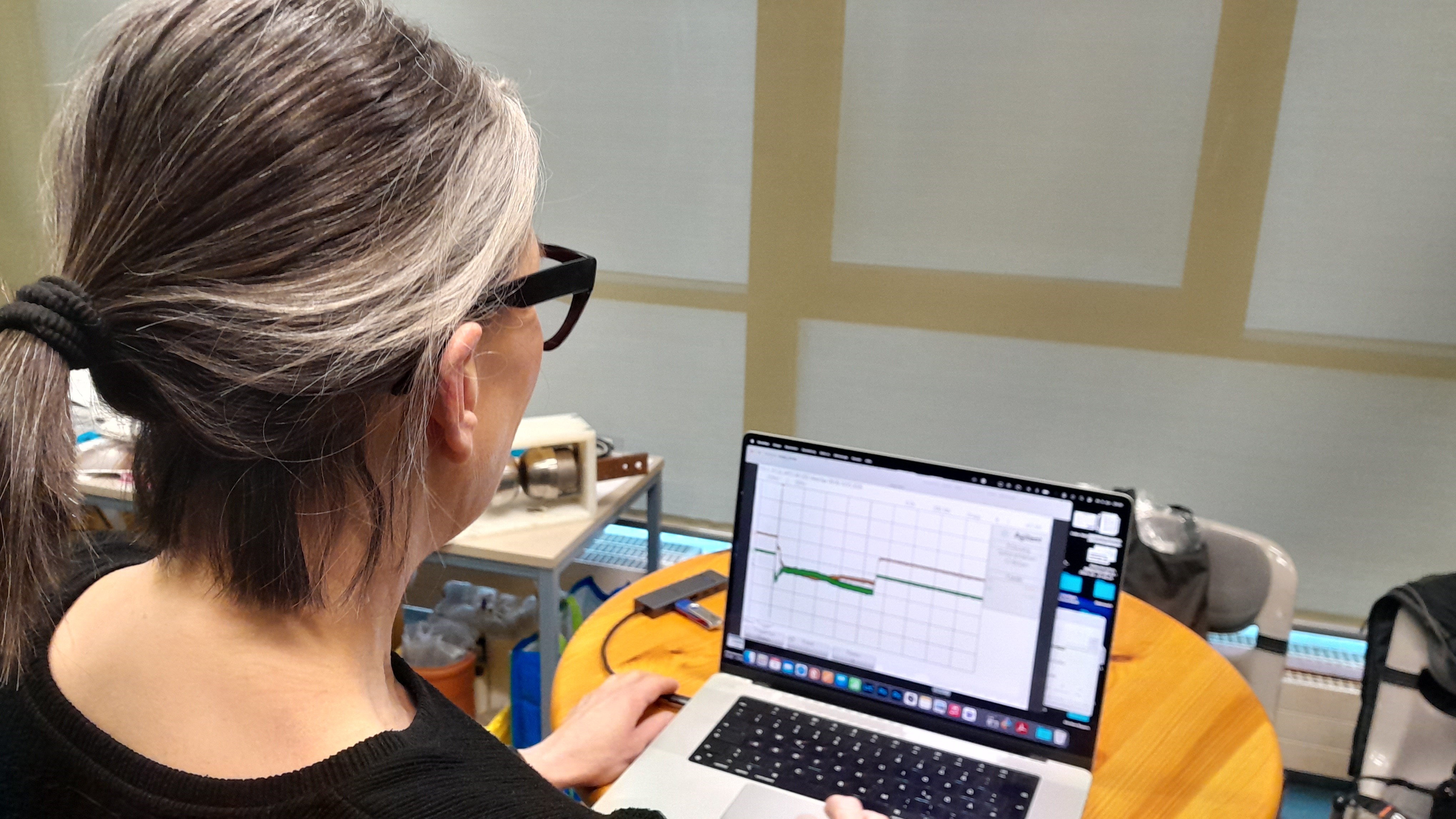 Eine Frau sitzt an einem Laptop und überwacht die abgegebenen Blitzströme im Hochspannungslabor der FH Kiel