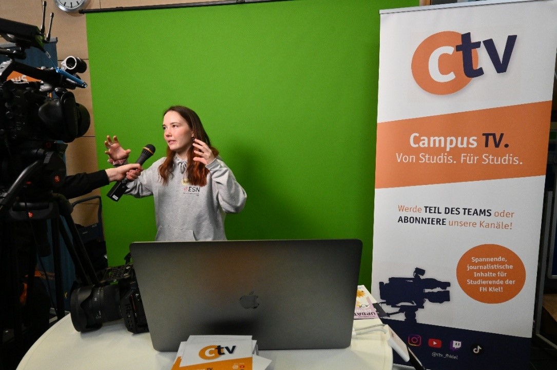 Frau steht vor Kamera und redet