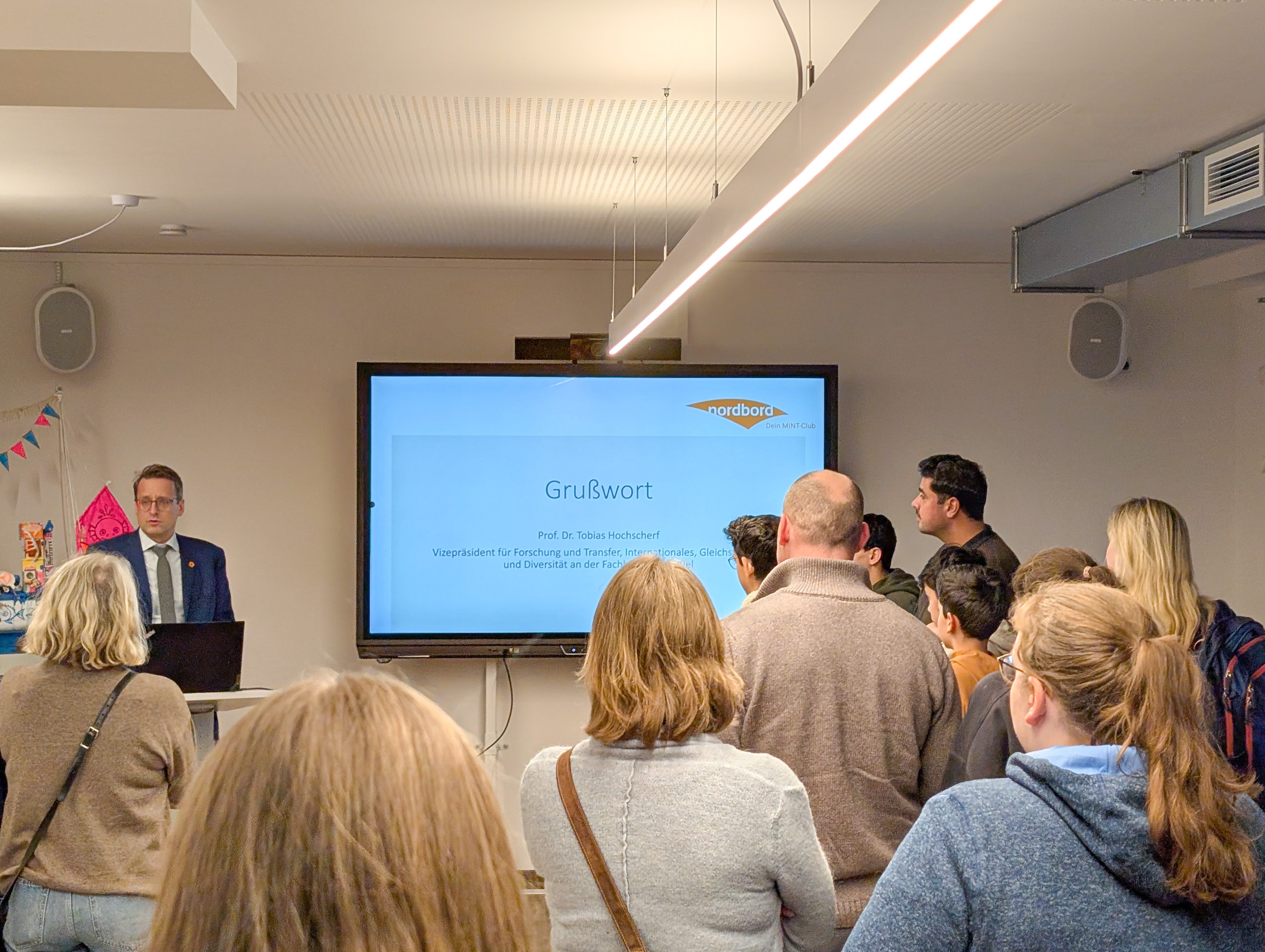 Prof. Dr. Tobias Hochscherf freut sich über die zahlreichen Besucher*innen.