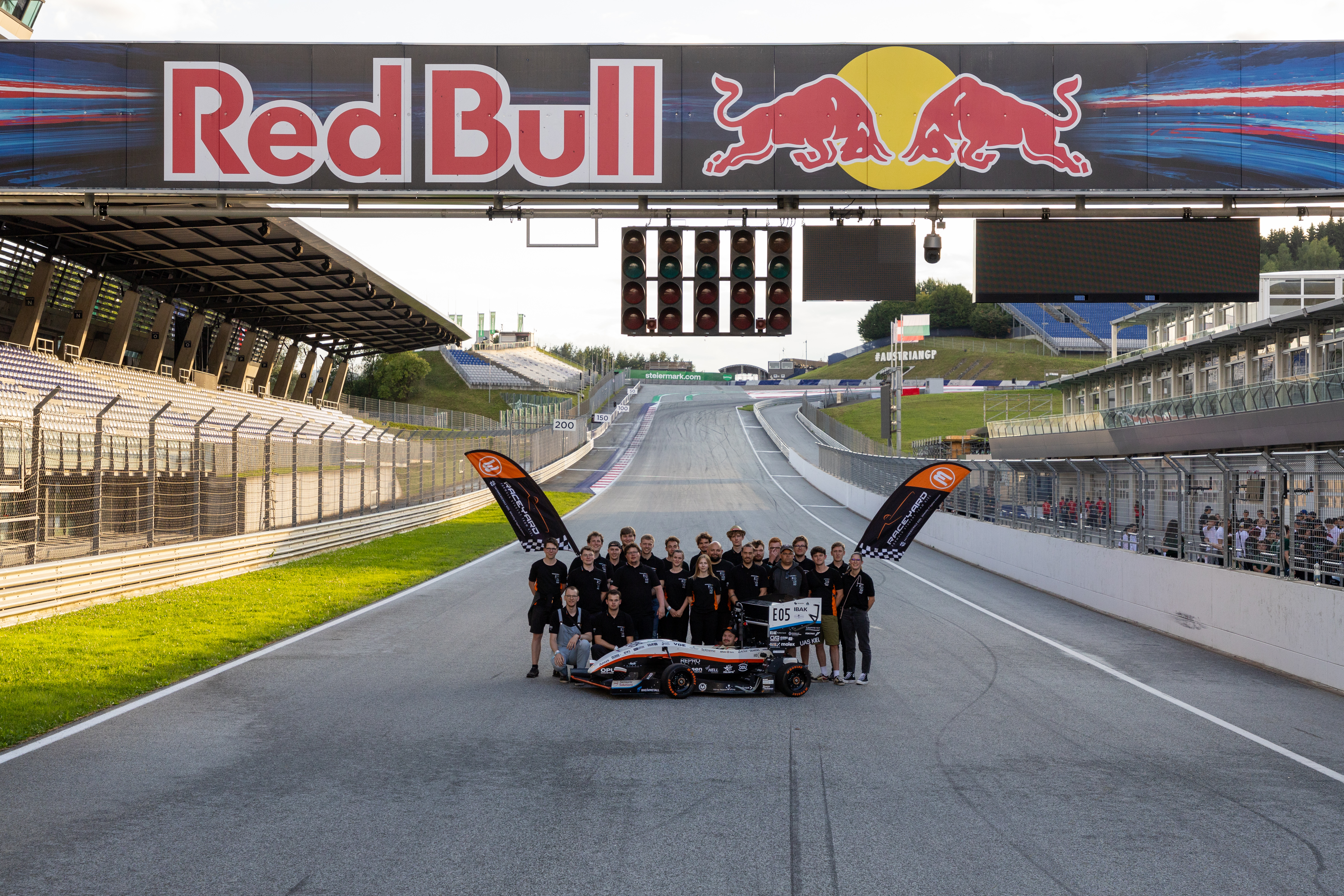 Das gesamte Raceyardteam steht auf einer Rennstrecke.