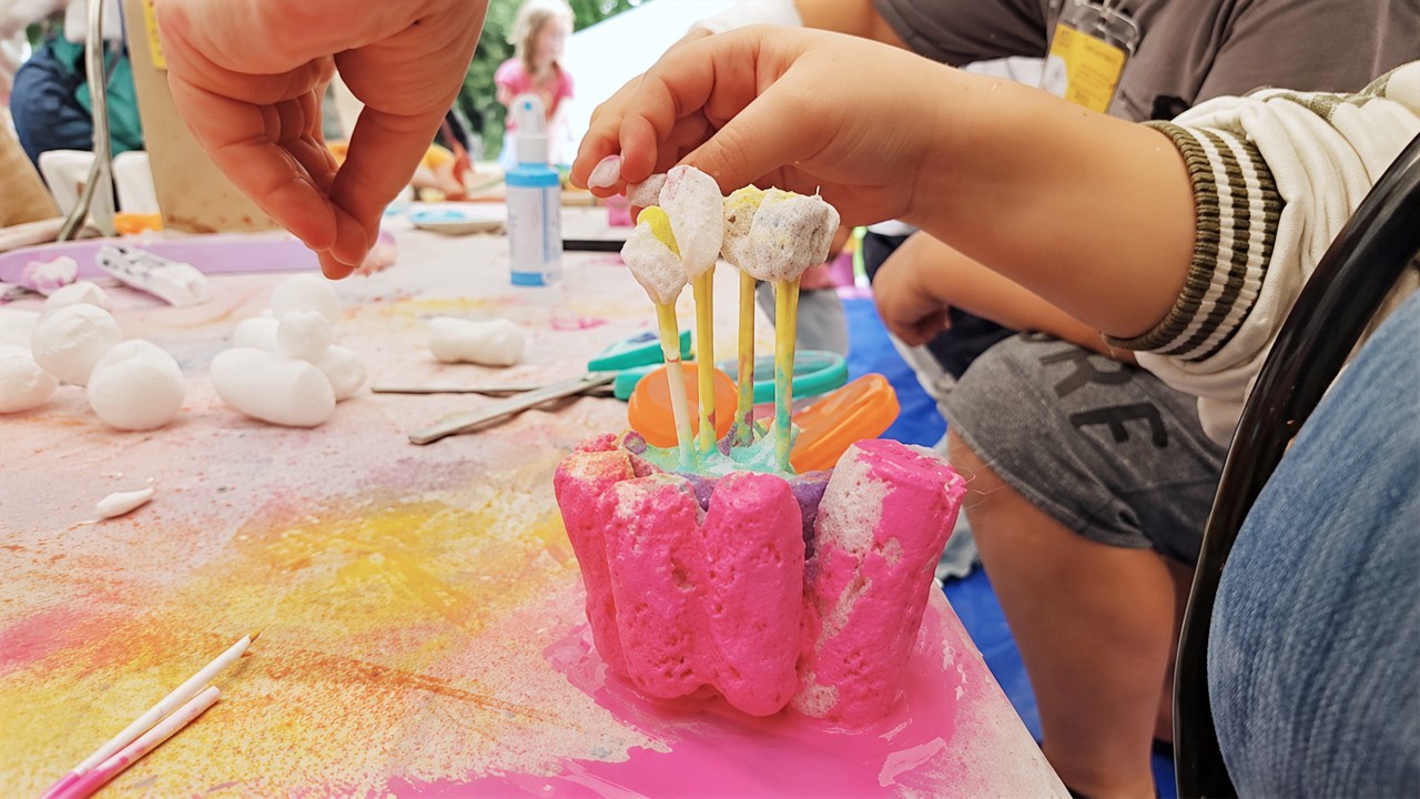 eine Kinderhand an einem gebastelten Objekt