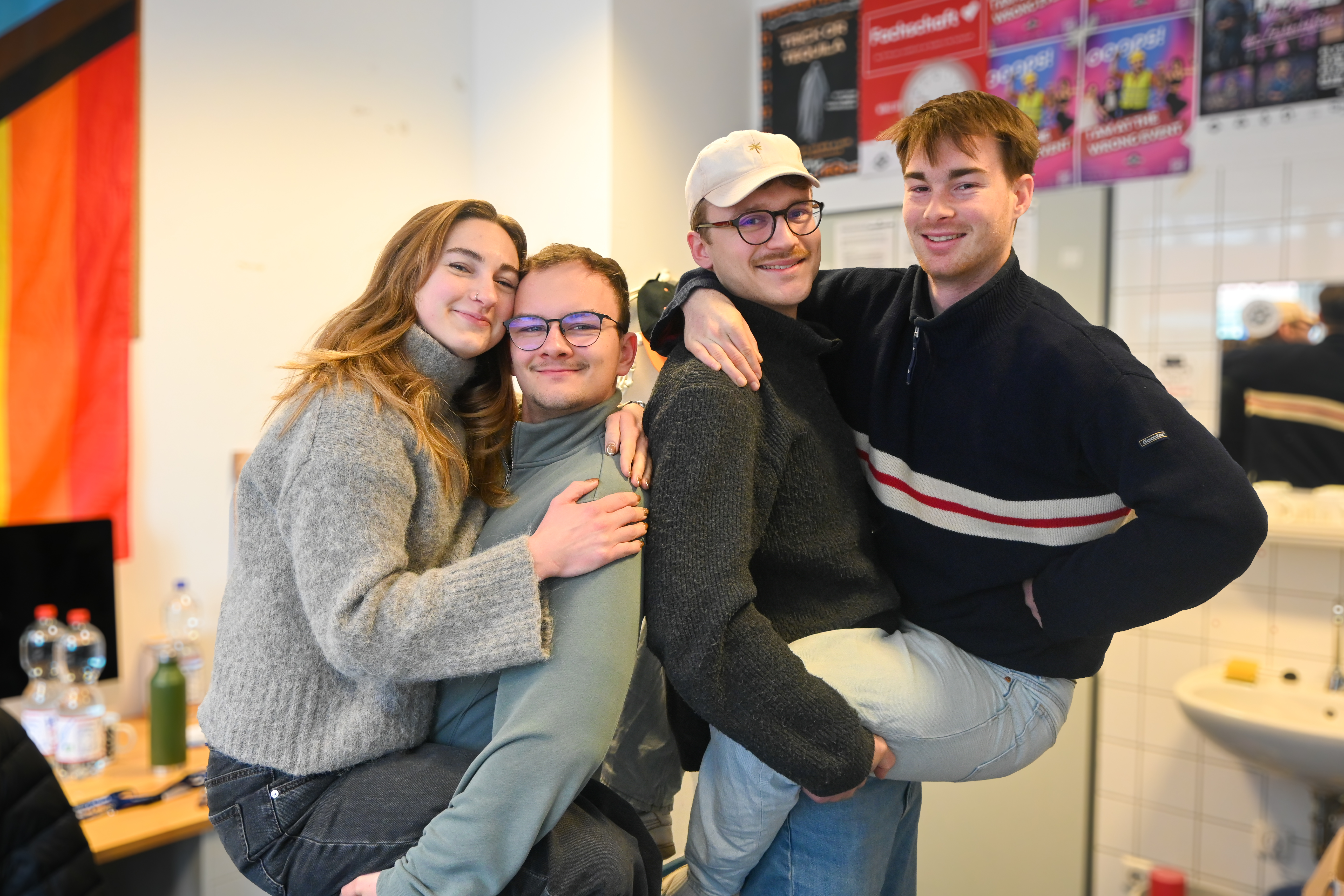 Zwei Personen halten je eine Person auf dem Arm.