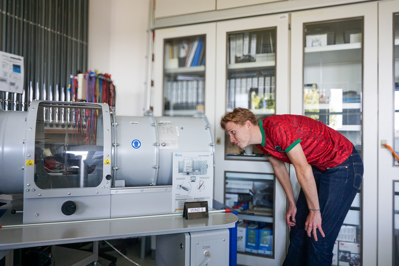 Ein Student schaut sich eine Windkraftanalge an.