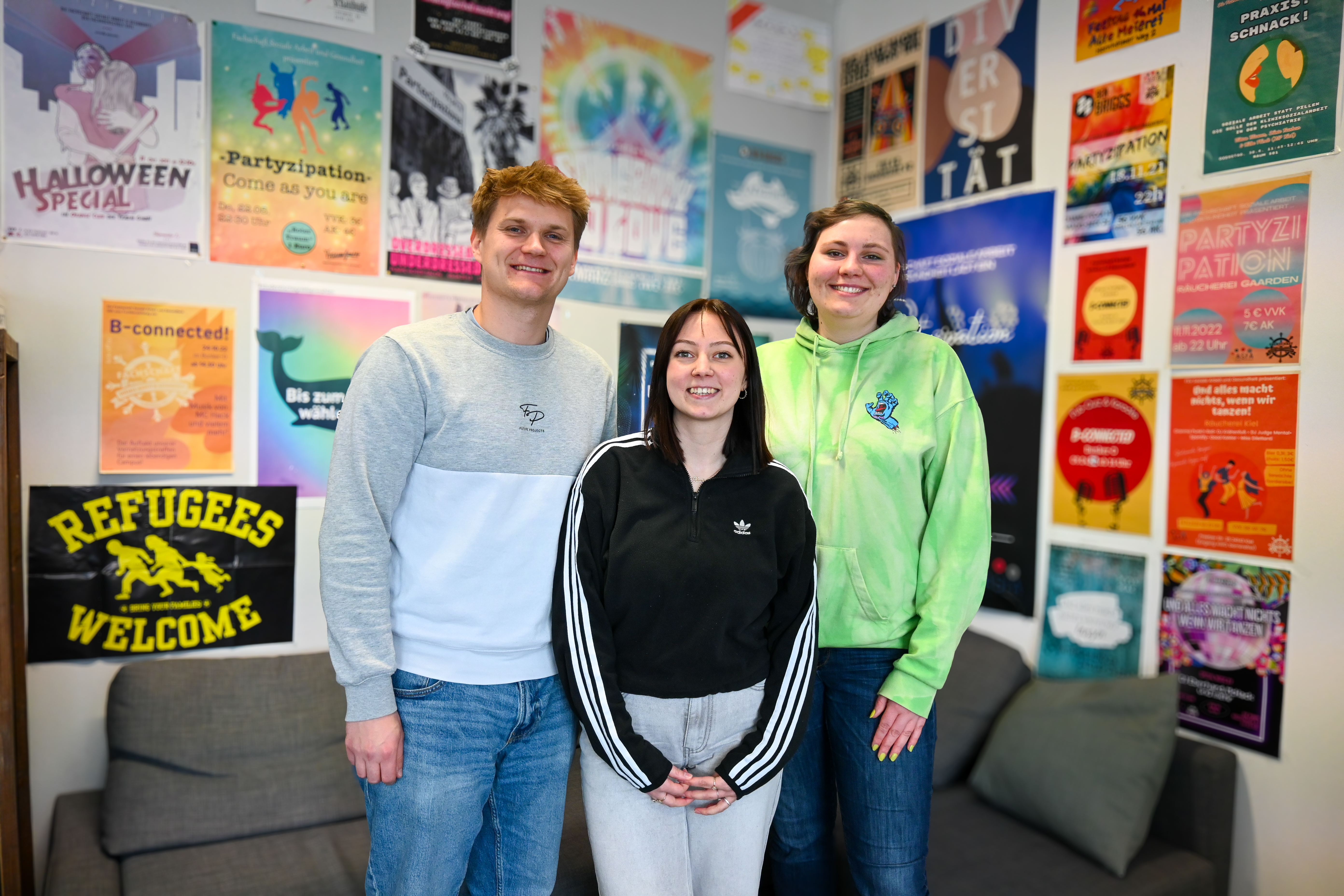 Drei Mitglieder der Fachschaft lachen in die Kamera.