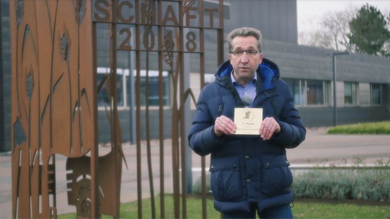 ein Mann mit einem Zertifikat in der Hand