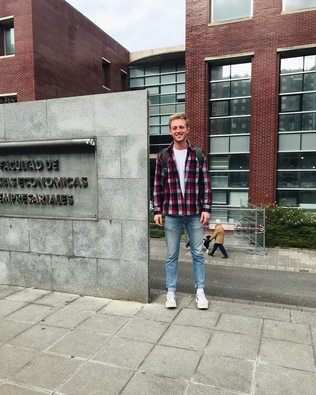 Tim steht bei seiner Ankunft in Santander vor einer Steintafel des Wirtschafts-Fachbereichs
