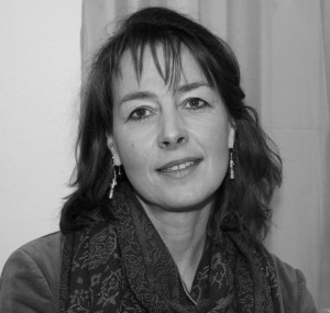 Das Schwarz-Weiß-Bild zeigt eine Frau, die selbstbewusst in die Kamera grinst.