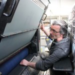 Ein Mann überprüft noch einmal den Ausgang der Druckerpresse.